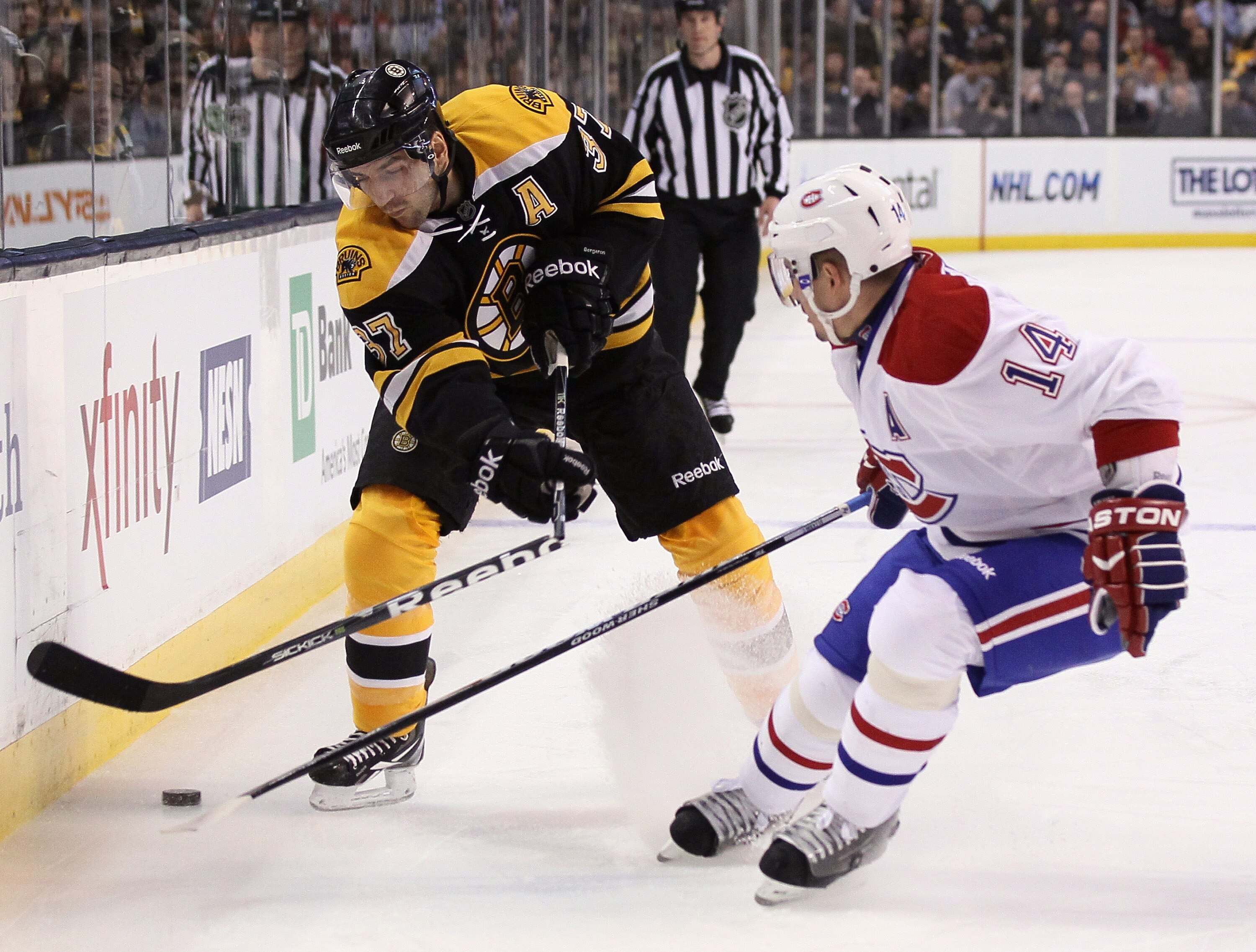 BOSTON, MA - MARCH 24:  Patrice Bergeron #37 of the Boston Bruins breaks his stick as he takes a shot while Tomas Plekanec #14 of the Montreal Canadiens defends on March 24, 2011 at the TD Garden in Boston, Massachusetts.  (Photo by Elsa/Getty Images)