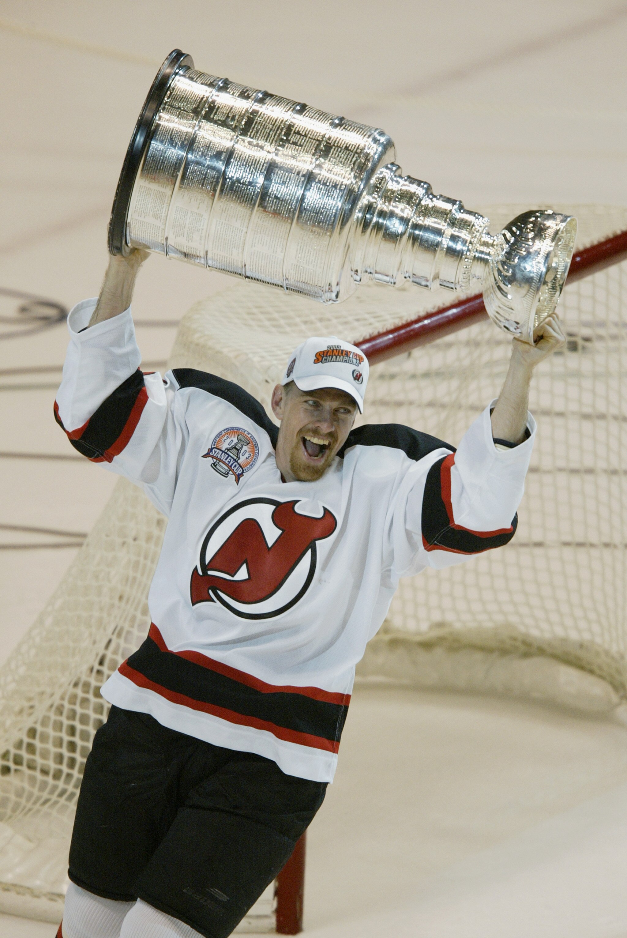 EAST RUTHERFORD, NJ - JUNE 9:   Joe Nieuwendyk #25 of the New Jersey Devils raises the Stanley Cup after defeating the Mighty Ducks of Anaheim in game seven of the 2003 Stanley Cup Finals at Continental Airlines Arena on June 9, 2003 in East Rutherford, N