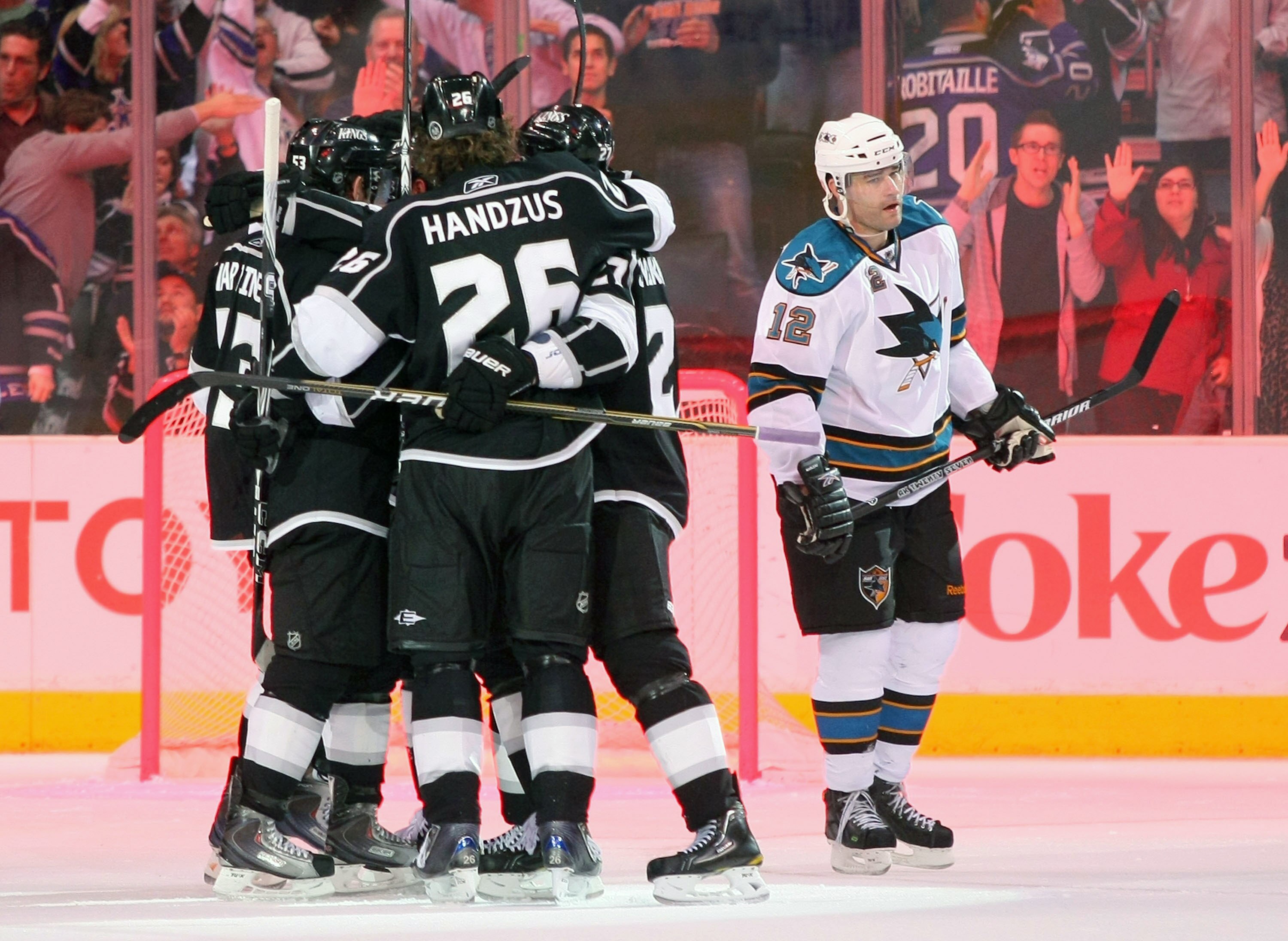 LOS ANGELES, CA - MARCH 24:  Alec Martinez #53, Michal Handzus #26, Dustin Brown #23 and Alexei Ponikarovsky #27 of the Los Angeles Kings celebrate Brown's goal in the third period as Patrick Marleau #12 of the San Jose Sharks skates to the bench during t