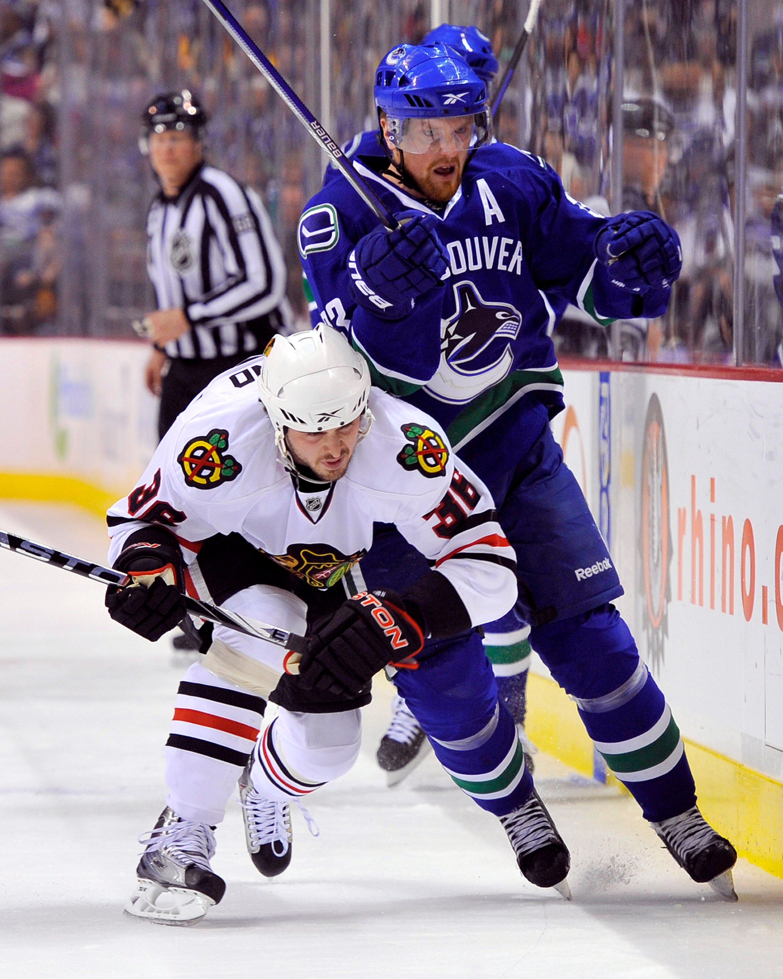 VANCOUVER, CANADA - MAY 5:  Henrik Sedin #33 of the Vancouver Canucks is hit by Dave Bolland #36 of the Chicago Blackhawks during the first period in Game Three of the Western Conference Semifinals during the 2010 NHL Stanley Cup Playoffs on May 5, 2010 a
