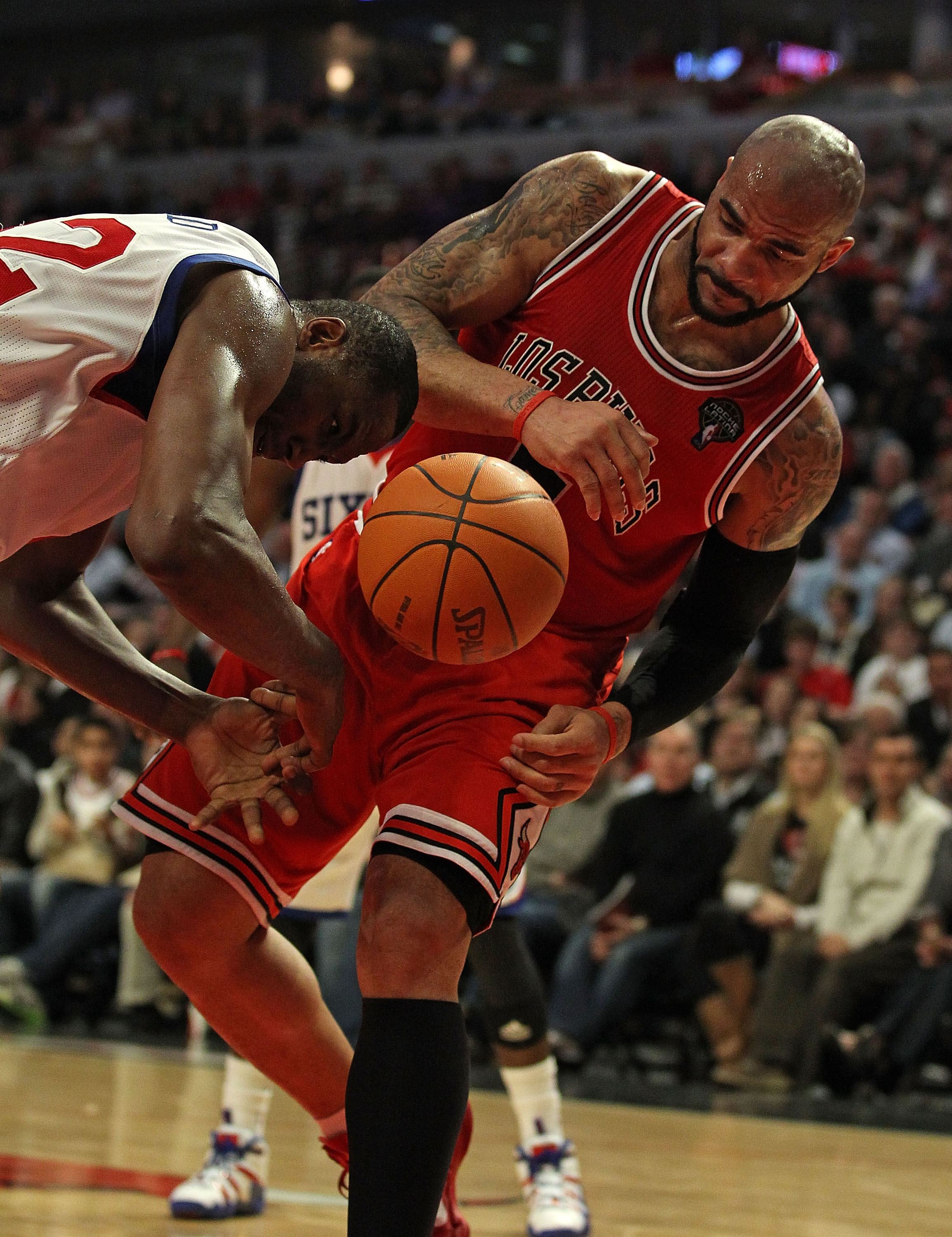 CHICAGO, IL - MARCH 28: Elton Brand #42 of the Philadelphia 76ers looses control of the ball next to Carlos Boozer #5 of the Chicago Bulls at the United Center on March 28, 2011 in Chicago, Illinois. The 76ers defeated the Bulls 97-85. NOTE TO USER: User