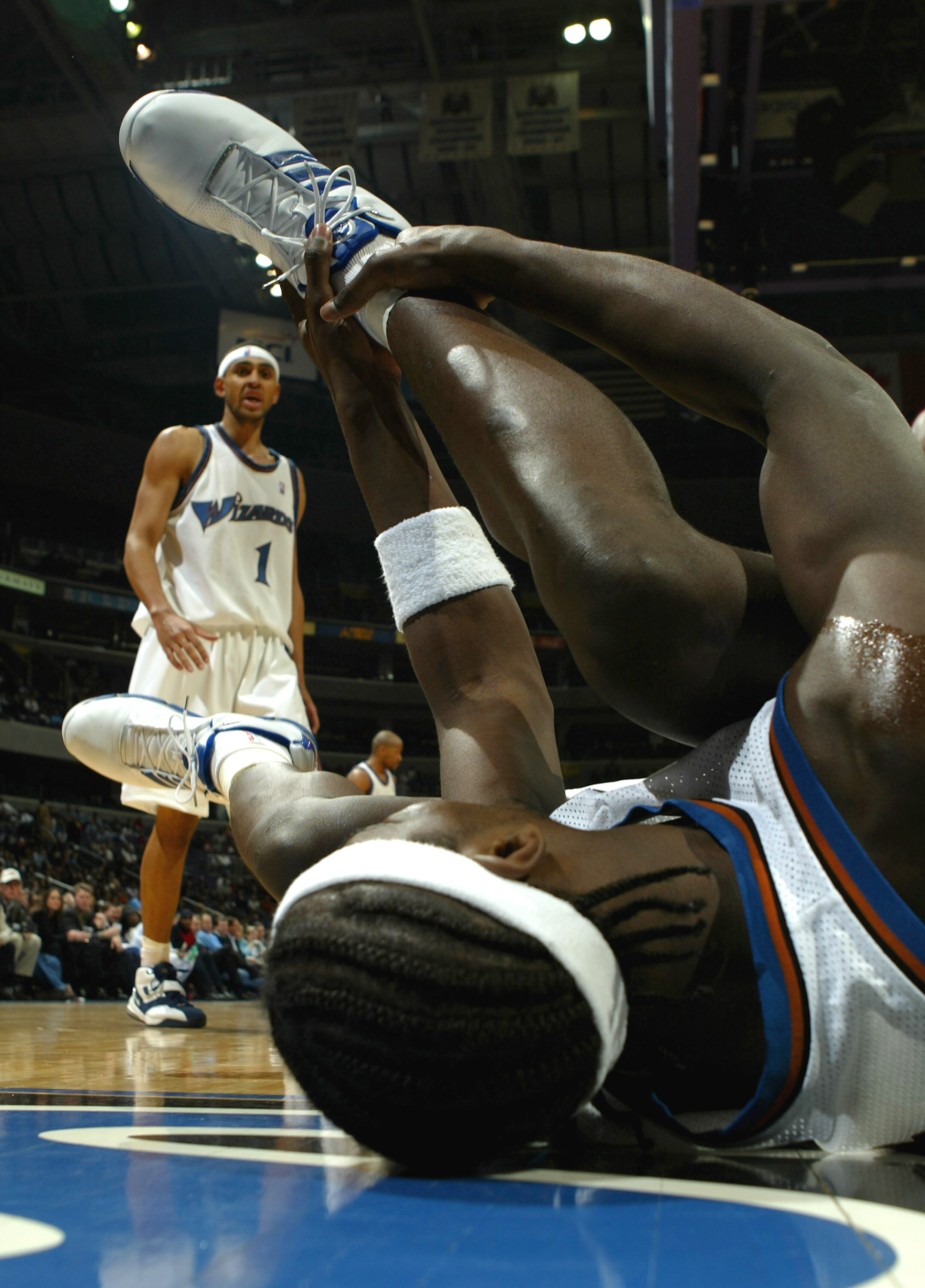WASHINGTON - MARCH 3:  Kwame Brown #5 of the Washington Wizards grabs his ankle after an awkward landing during fourth quarter action on March 3, 2004 at the MCI Center in Washington, DC.  NOTE TO USER:  User expressly acknowledges and agrees that, by dow