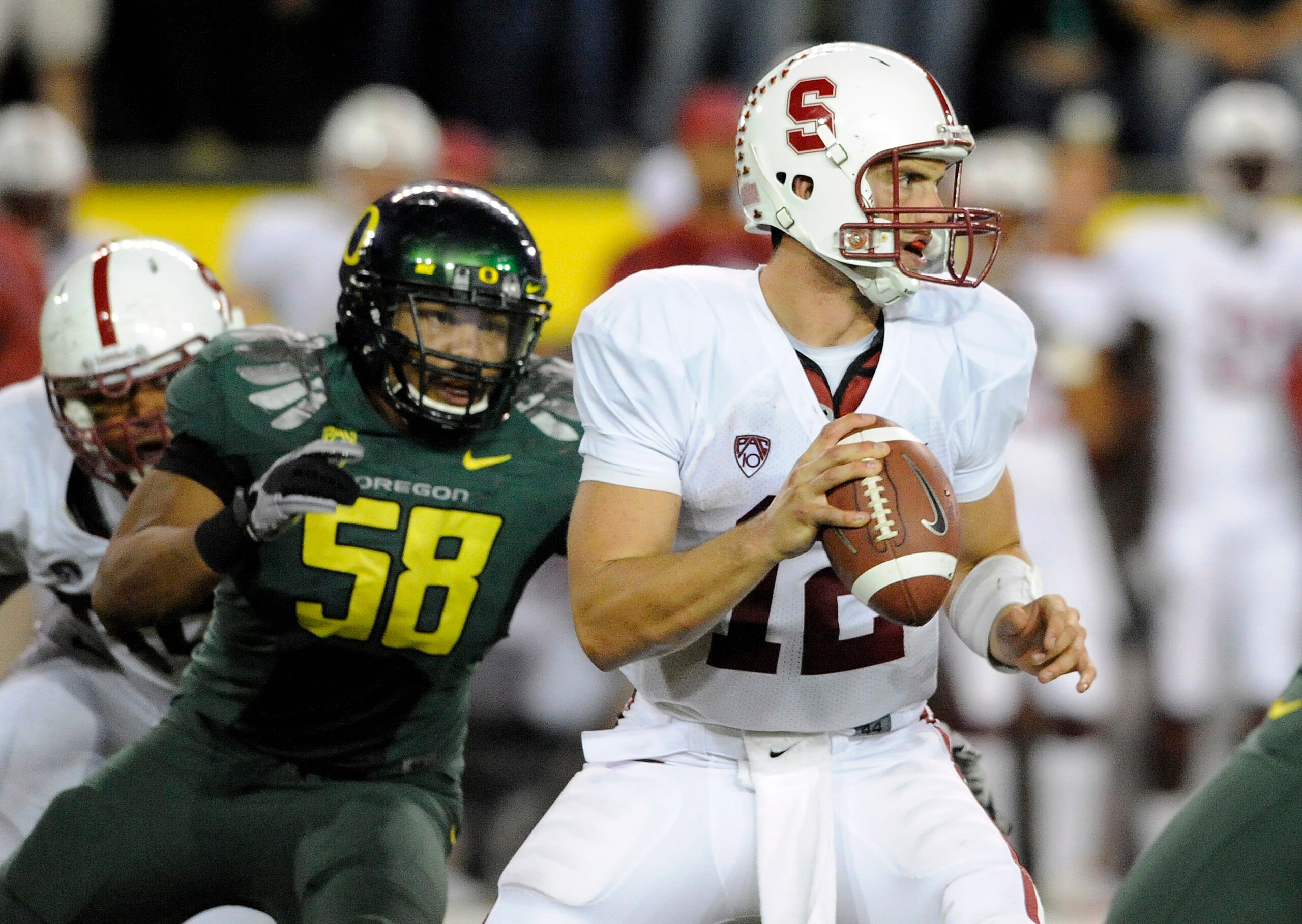 EUGENE, OR - OCTOBER 2: Quarterback Andrew Luck #12 of the Stanford Cardinal is pressured by defensive end Kenny Rowe #58 of the Oregon Ducks in the third quarter of the game at Autzen Stadium on October 2, 2010 in Eugene, Oregon. Oregon won the game 52-3 EUGENE, OR - OCTOBER 2: Quarterback Andrew Luck #12 of the Stanford Cardinal is pressured by defensive end Kenny Rowe #58 of the Oregon Ducks in the third quarter of the game at Autzen Stadium on October 2, 2010 in Eugene, Oregon. Oregon won the game 52-3