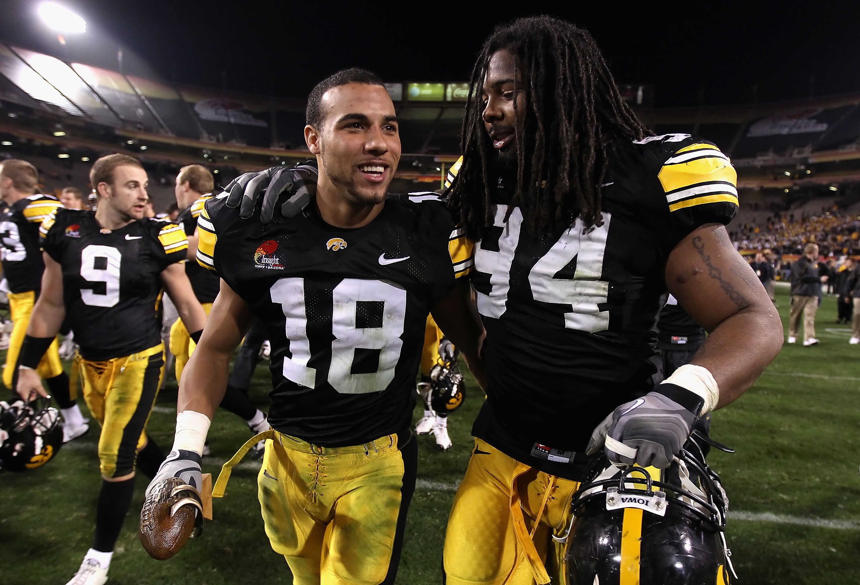 TEMPE, AZ - DECEMBER 28:  Defensive player of the game Micah Hyde #18 and Adrian Clayborn #94 of the Iowa Hawkeyes walk off the field after defeating the Missouri Tigers in the Insight Bowl at Sun Devil Stadium on December 28, 2010 in Tempe, Arizona. The