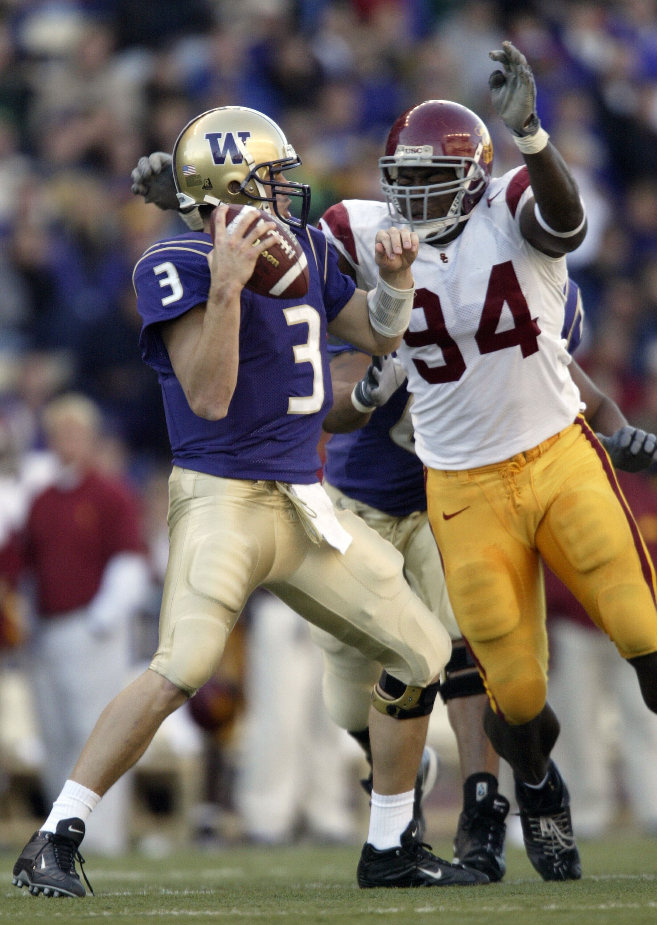 SEATTLE - OCTOBER 25:  Quarterback Cody Pickett #3 of the University of Washington Huskies is sacked by Kenechi Udeze #94 of the University of Southern California Trojans on October 25, 2003 at Husky Stadium in Seattle, Washington.  (Photo by Otto Greule