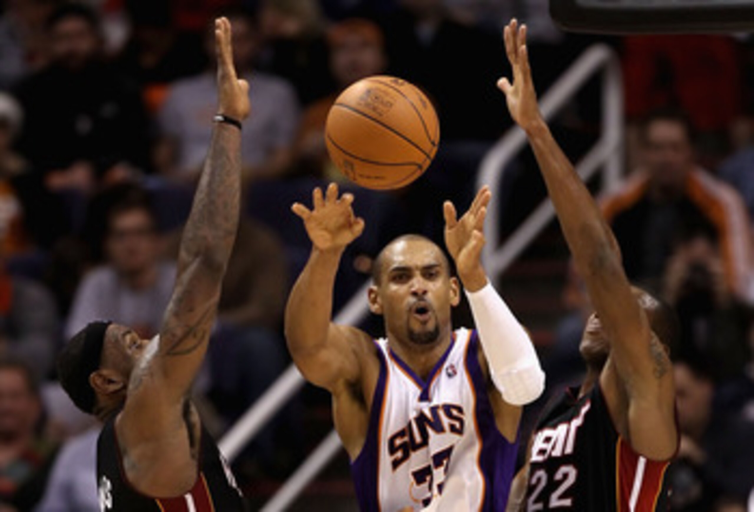 PHOENIX - DECEMBER 23:  Grant Hill #33 of the Phoenix Suns passes the ball under pressure from LeBron James #6 and James Jones #22 of the Miami Heat during the NBA game at US Airways Center on December 23, 2010 in Phoenix, Arizona. The Heat defeated the S