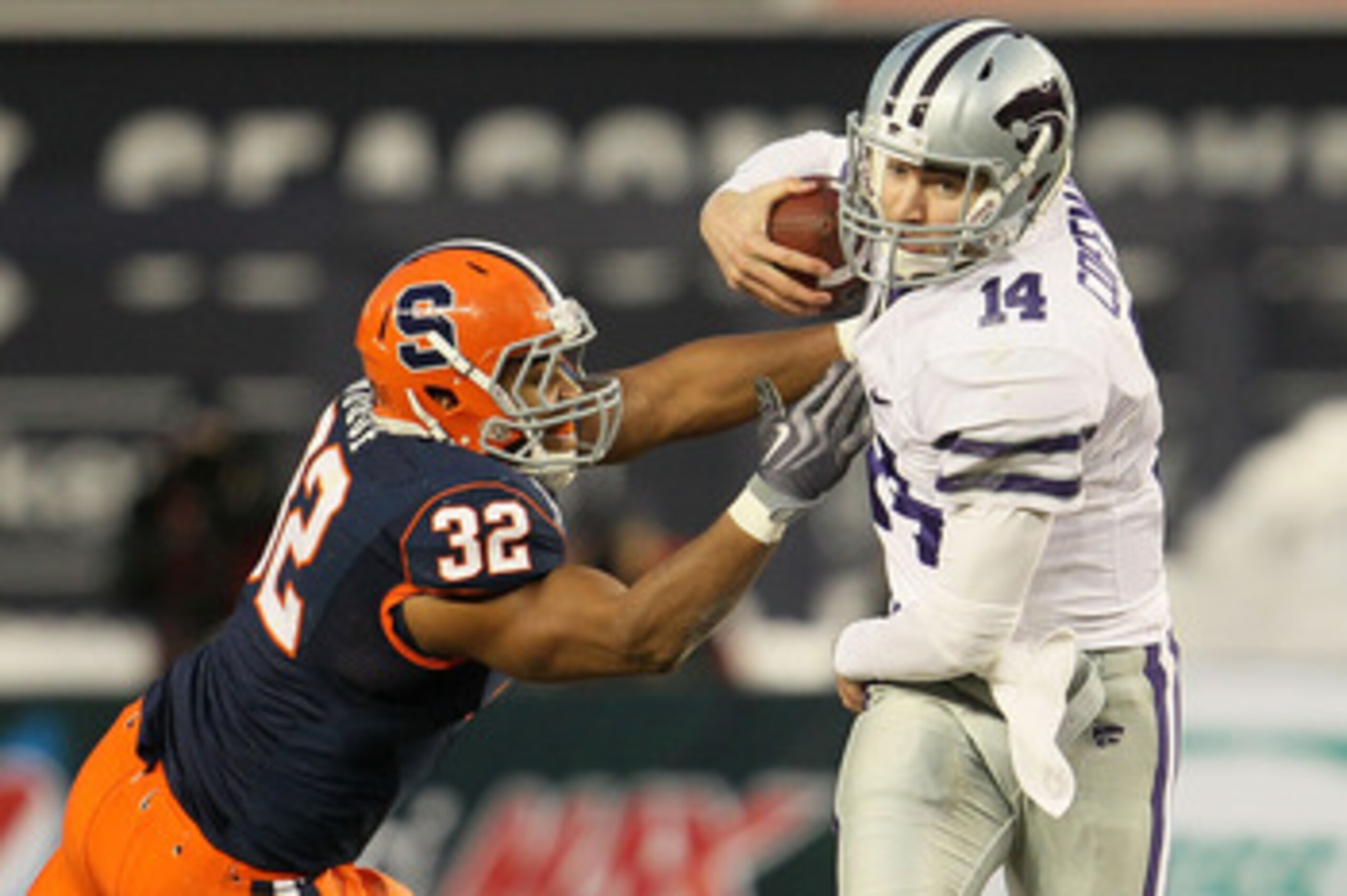 NEW YORK, NY - DECEMBER 30:  Carson Coffman #14 of the Kansas State Wildcats gets out of the tackle of Doug Hogue #32 of the Syracuse Orange during the New Era Pinstripe Bowl at Yankee Stadium on December 30, 2010 in New York, New York.  (Photo by Chris M