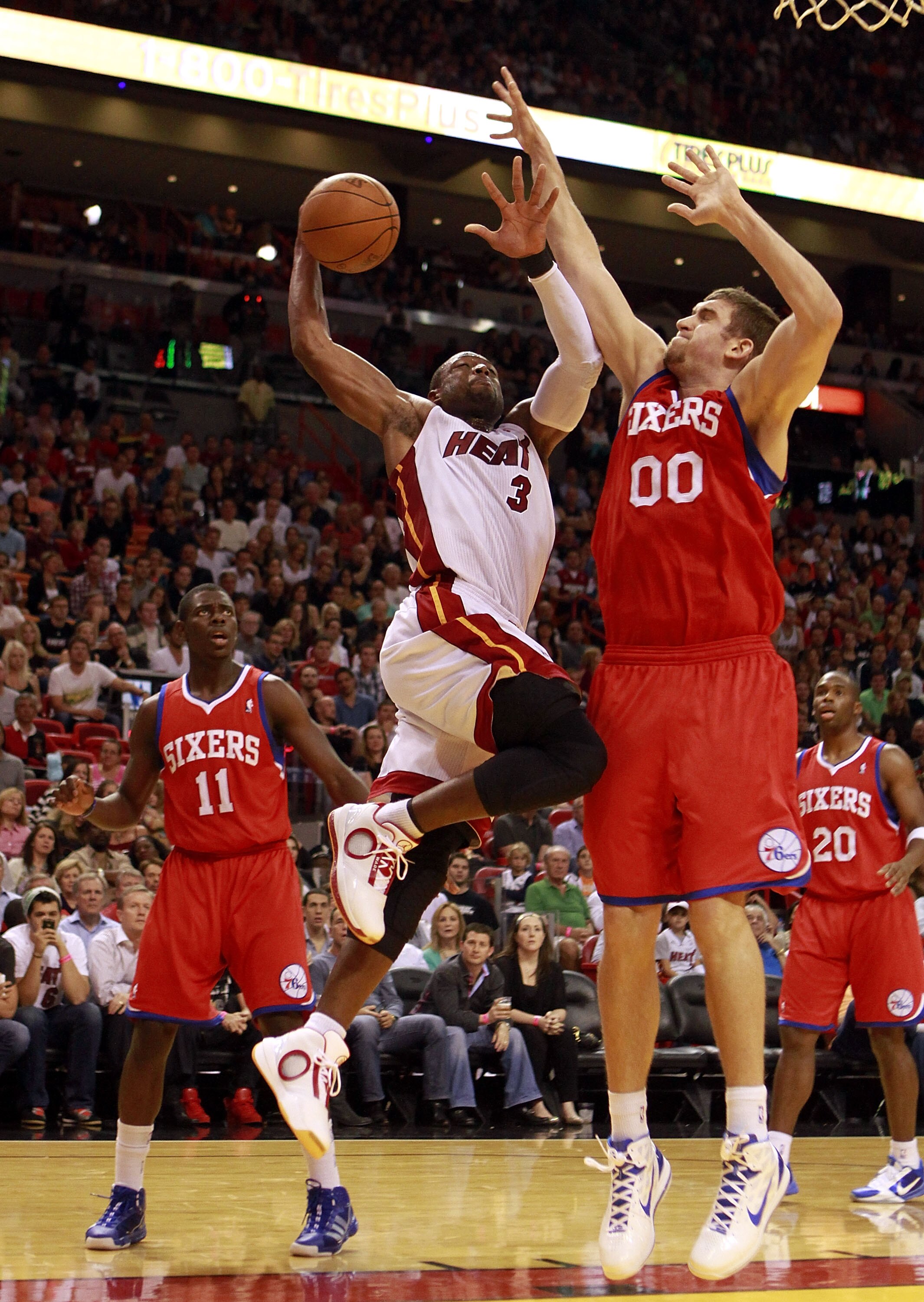MIAMI - NOVEMBER 26:  Dwyane Wade #3 of the Miami Heat is fouled by Spencer Hawes #00 of the Philadelphia 76ers at American Airlines Arena on November 26, 2010 in Miami, Florida. The Heat defeated the 76ers 99-90. NOTE TO USER: User expressly acknowledges