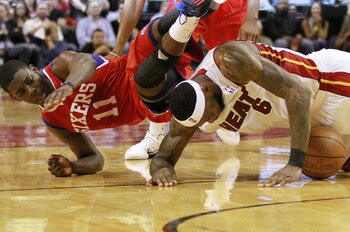 MIAMI, FL - MARCH 25: Forward LeBron James #6 of the Miami Heat  battles for the ball with Guard Jrue Holiday #11 of the Philadelphia Sixers at American Airlines Arena on March 25, 2011 in Miami, Florida. NOTE TO USER: User expressly acknowledges and agre