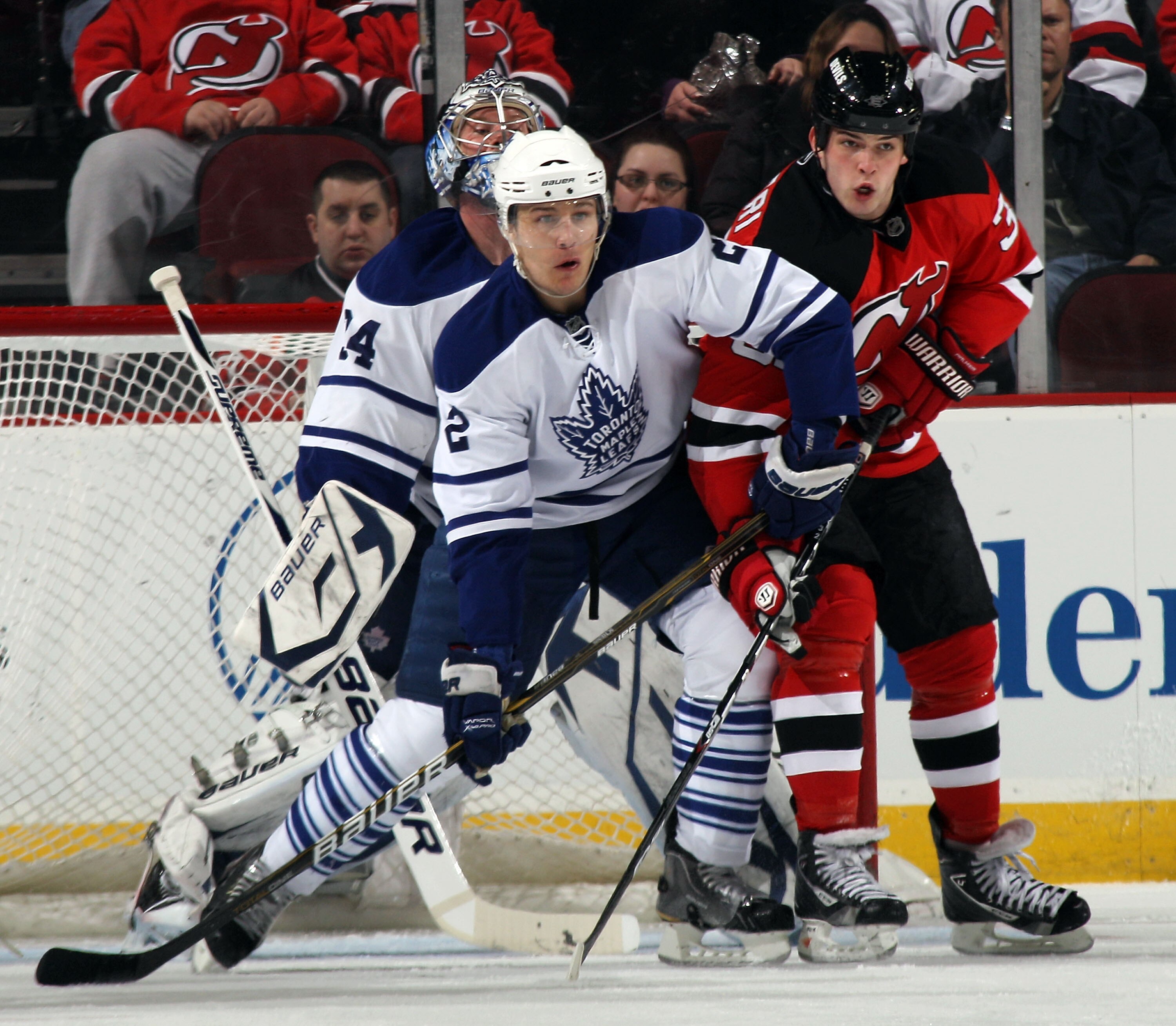 NEWARK, NJ - APRIL 06: Luke Schenn #2 of the Toronto Maple Leafs and Nick Palmieri #32 of the New Jersey Devils battle in front of the net at the Prudential Center on April 6, 2011 in Newark, New Jersey.  (Photo by Bruce Bennett/Getty Images)