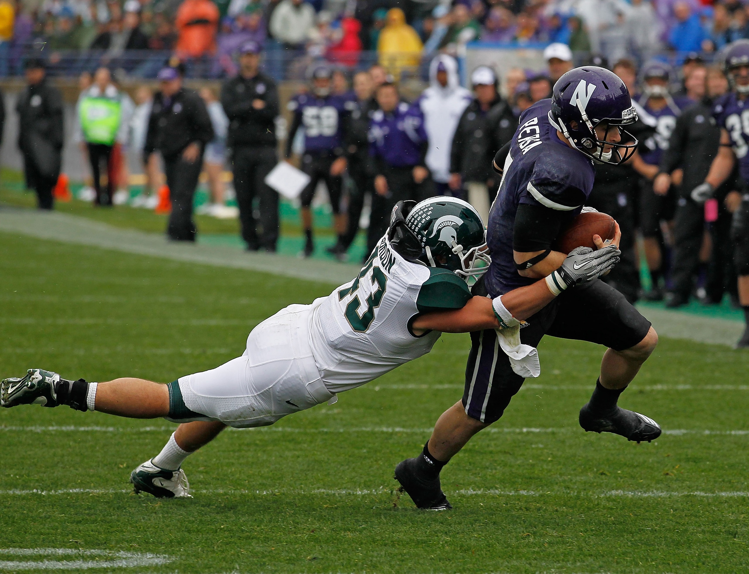 EVANSTON, IL - OCTOBER 23: Dan Persa #7 of the Northwestern Wildcats escapes a tackle attempt by Eric Gordon #43 of the Michigan State Spartans at Ryan Field on October 23, 2010 in Evanston, Illinois. Michigan State defeated Northwestern 35-27.  (Photo by