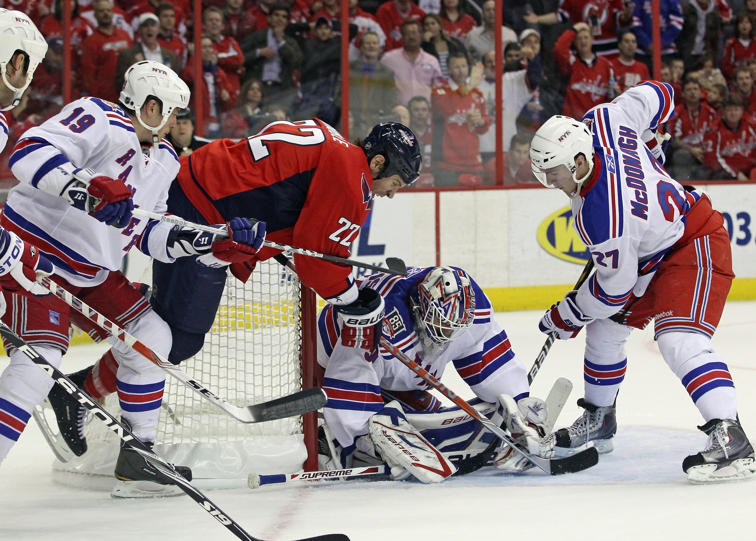 WASHINGTON, DC - APRIL 13:  Henrik Lundqvist #30 of the New York Rangers makes the save as Mike Knuble #22 of the Washington Capitals flies past him in Game One of the Eastern Conference Quarterfinals during the 2011 NHL Stanley Cup Playoffs at Verizon Ce