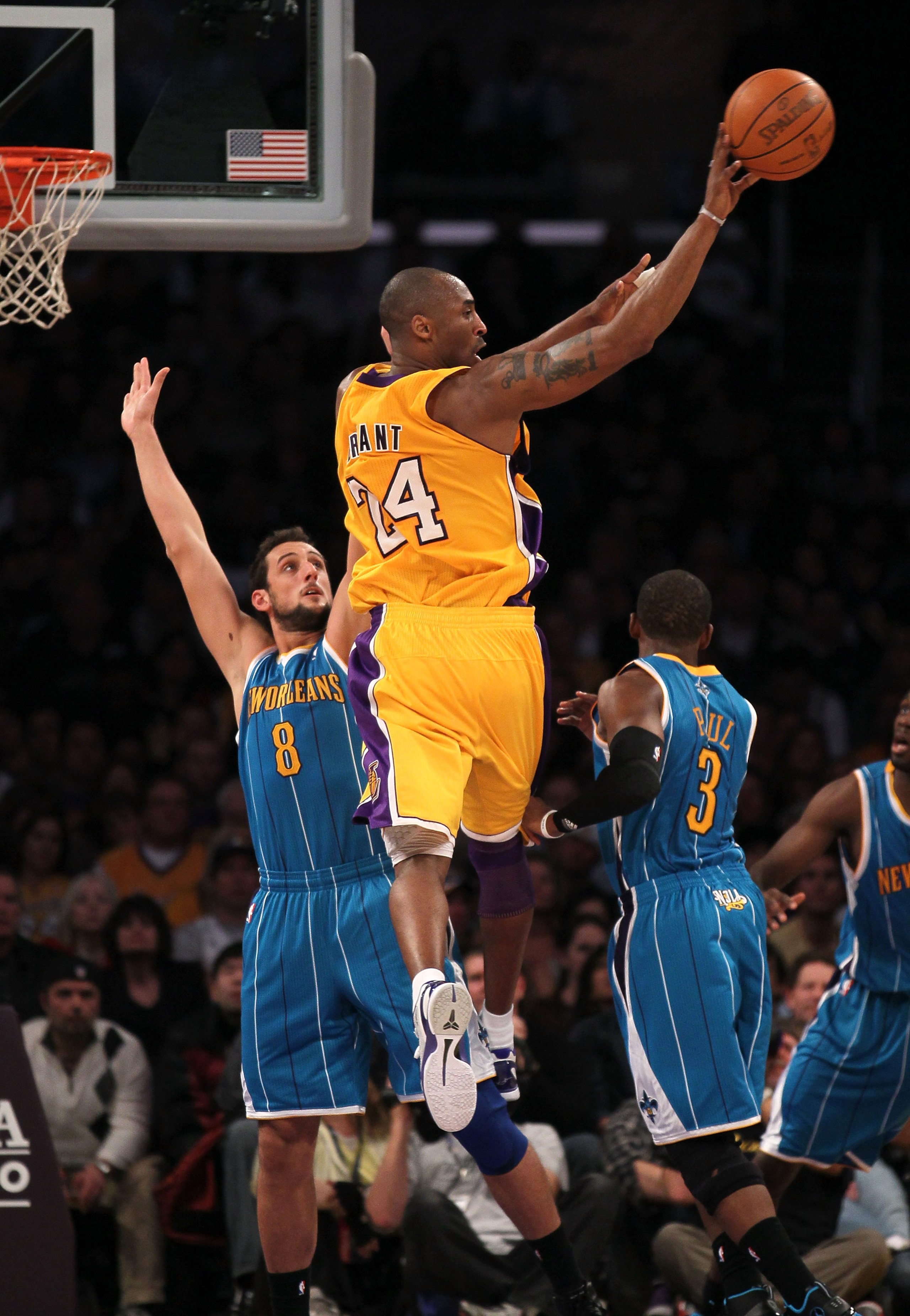LOS ANGELES, CA - JANUARY 07:  Kobe Bryant #24 of the Los Angeles Lakers dishes of the ball in front of Marco Belinelli #8 of the New Orleans Hornets at Staples Center on January 7, 2011 in Los Angeles, California.  The Lakers won 101-97.  NOTE TO USER: U