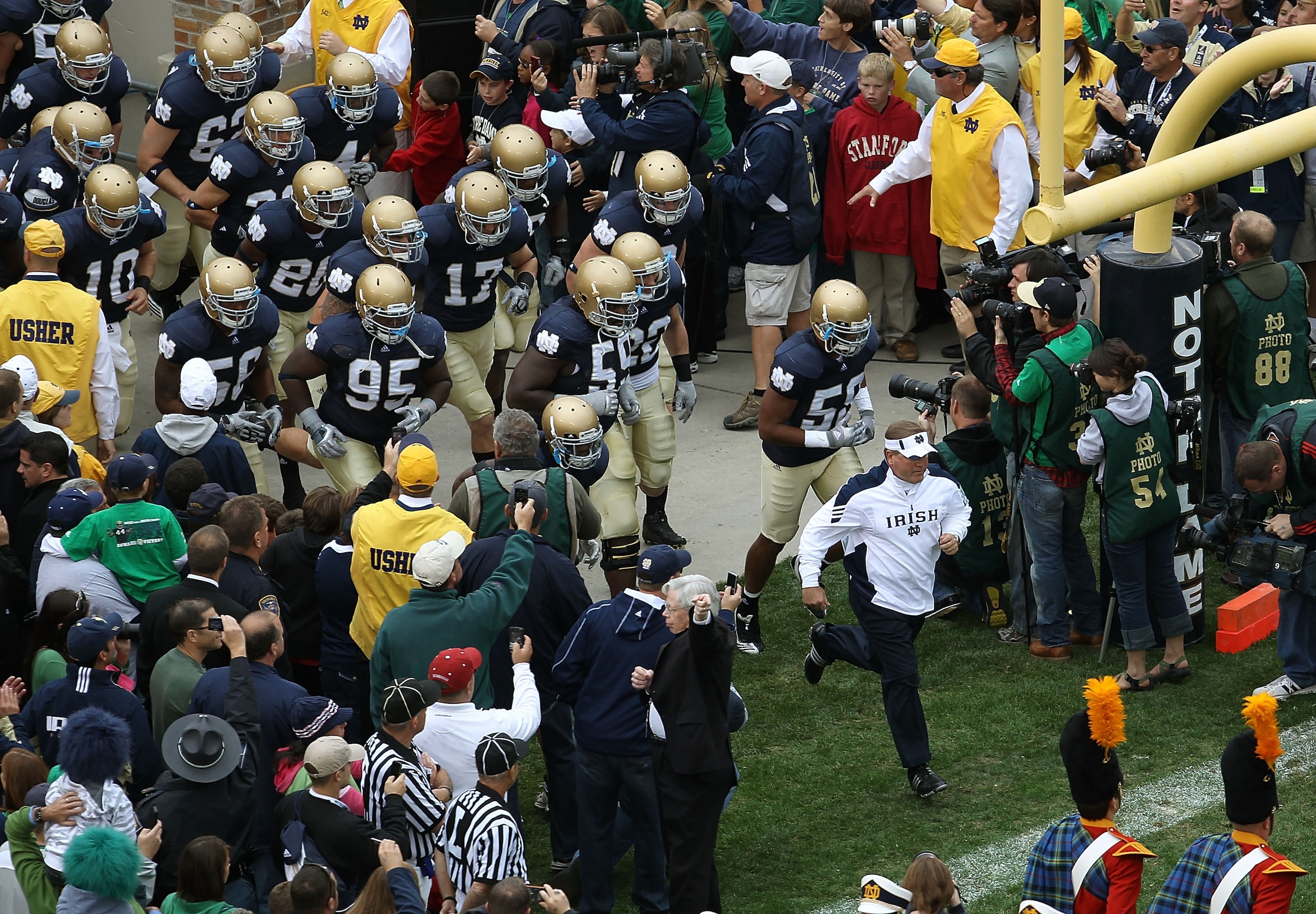 SOUTH BEND, IN - SEPTEMBER 25: Head coach Brian Kelly of the Notre Dame Fighting Irish leads his team onto the field before taking on the Stanford Cardinal at Notre Dame Stadium on September 25, 2010 in South Bend, Indiana. Stanford defeated Notre Dame 37 SOUTH BEND, IN - SEPTEMBER 25: Head coach Brian Kelly of the Notre Dame Fighting Irish leads his team onto the field before taking on the Stanford Cardinal at Notre Dame Stadium on September 25, 2010 in South Bend, Indiana. Stanford defeated Notre Dame 37