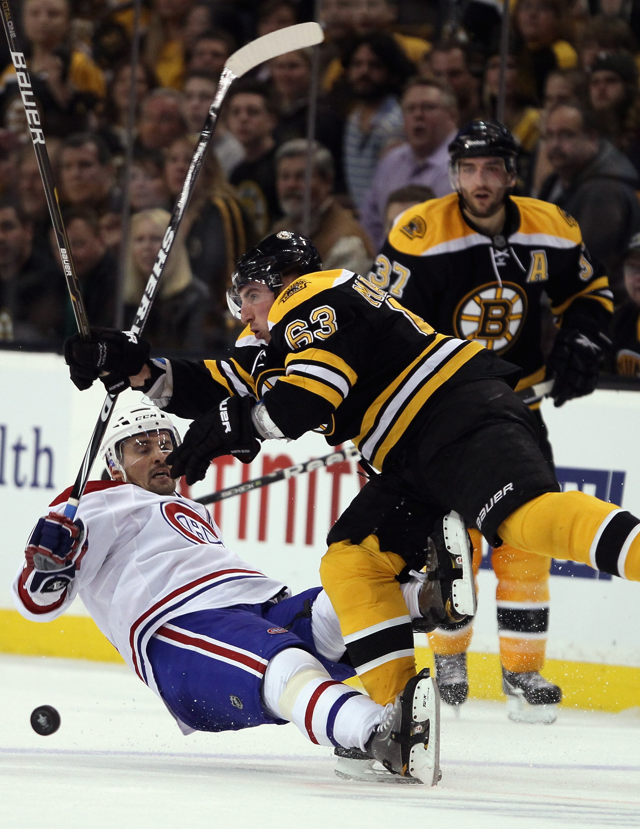 BOSTON, MA - APRIL 14:  Brad Marchand #63 of the Boston Bruins hits Tomas Plekanec #14 of the Montreal Canadiens  in Game One of the Eastern Conference Quarterfinals during the 2011 NHL Stanley Cup Playoffs at TD Garden on April 14, 2011 in Boston, Massac