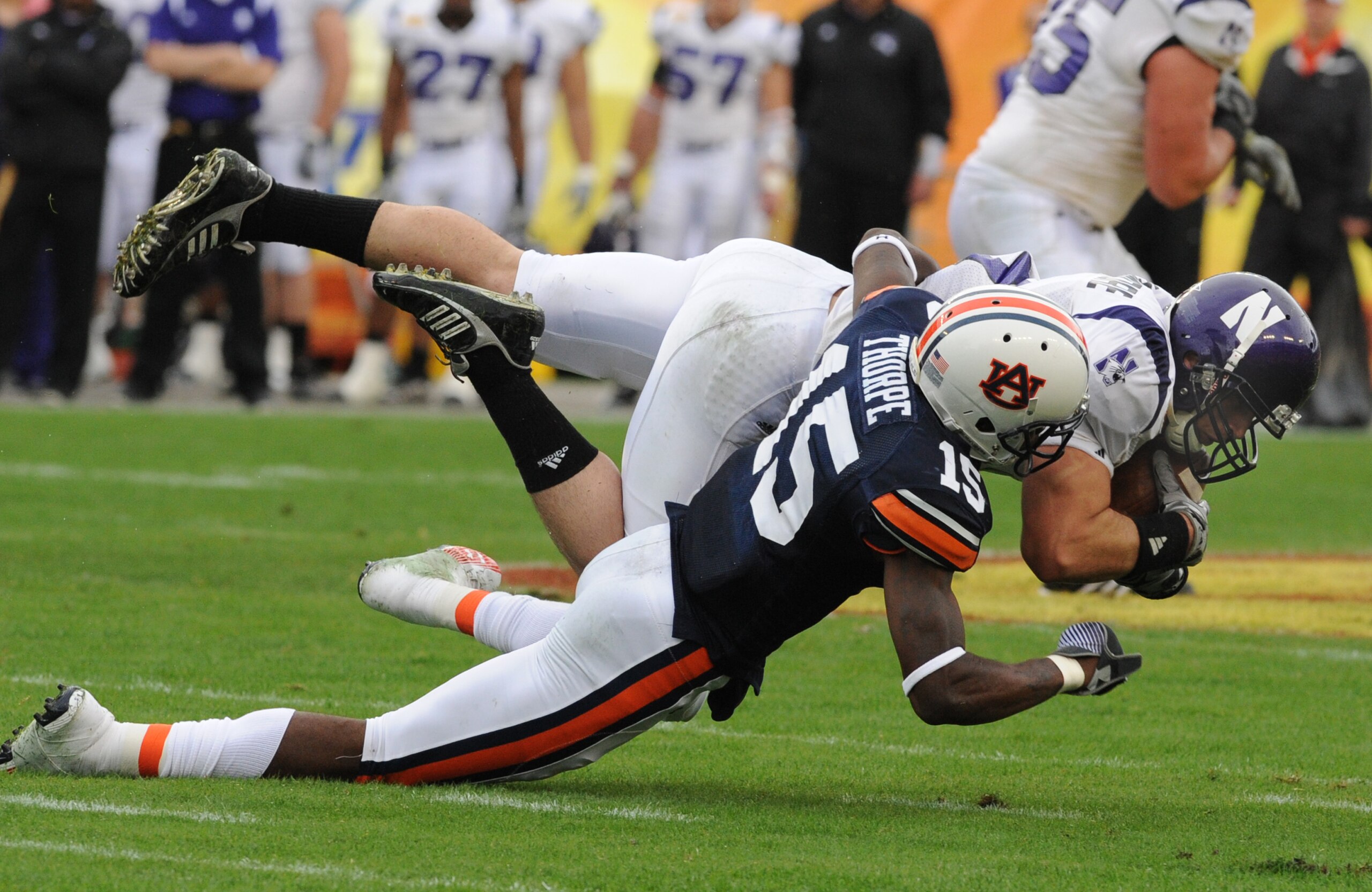 TAMPA, FL - JANUARY 1: Defensive back Neiko Thorpe #15 of the Auburn Tigers tackles split back Drake Dunsmore #9 of the Northwestern Wildcats in the Outback Bowl January 1, 2010 at Raymond James Stadium in Tampa, Florida.  (Photo by Al Messerschmidt/Getty