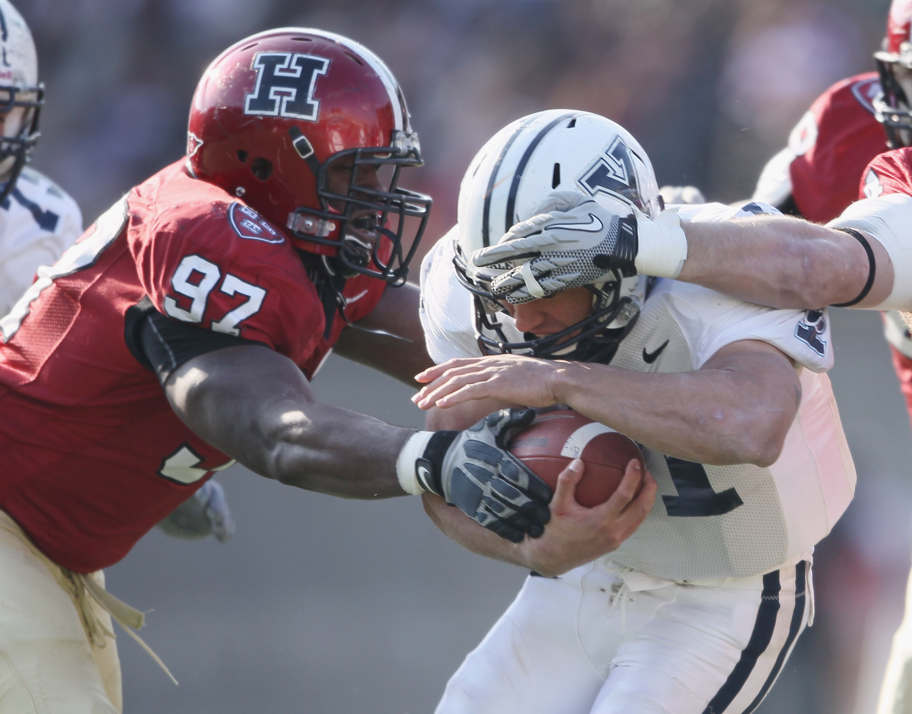 CAMBRIDGE, MA - NOVEMBER 20:  Chuks Obi #97 of the Harvard Crimson tackles Alex Thomas #41 of the Yale Bulldogs on November 20, 2010 at Harvard Stadium in Cambridge, Massachusetts.  Harvard defeated Yale 28-21.  (Photo by Elsa/Getty Images)