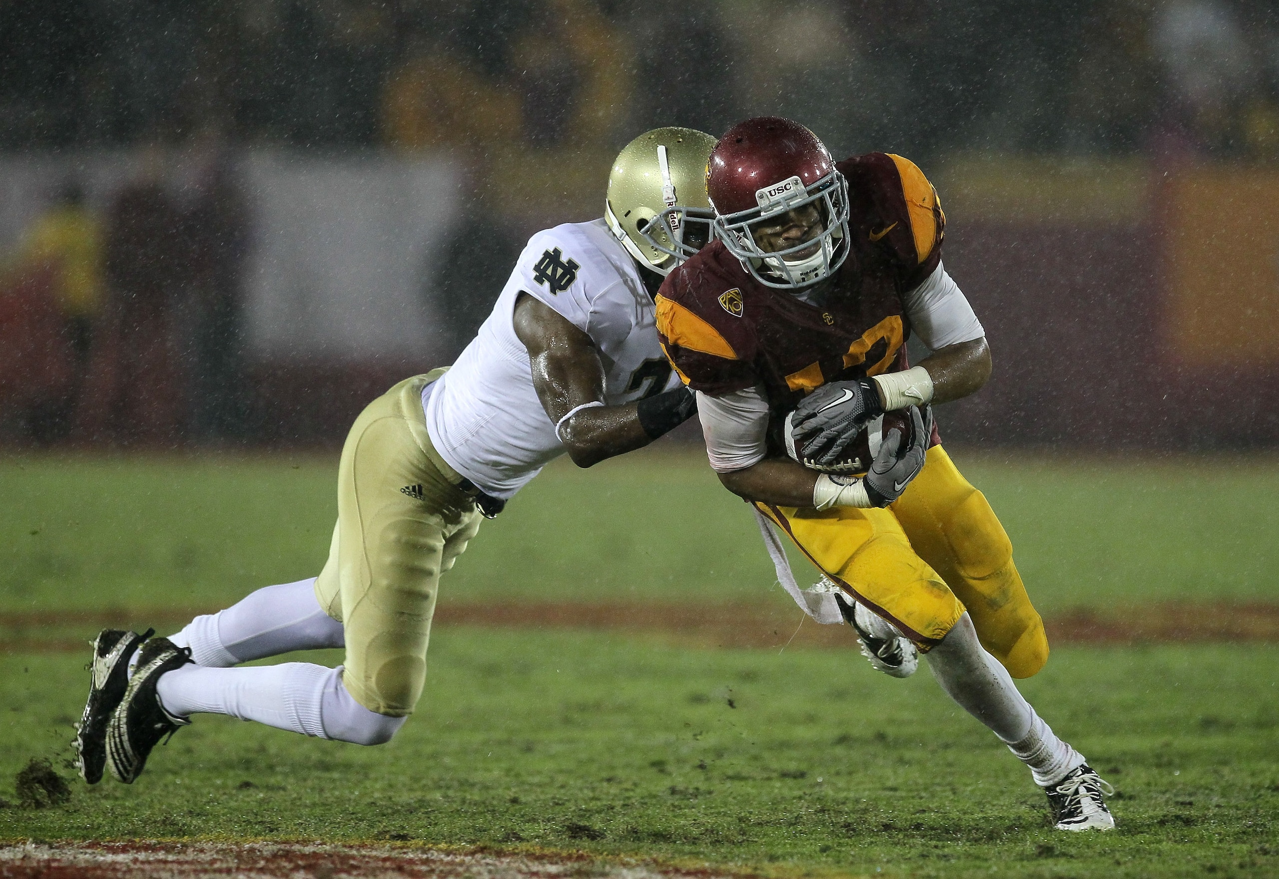 LOS ANGELES - NOVEMBER 27:  Wide receiver Robert Woods #13 of the USC Trojans carries the ball against cornerback Darrin Walls #2 of the Notre Dame Fighting Irish at the Los Angeles Memorial Coliseum on November 27, 2010 in Los Angeles, California.  Notre
