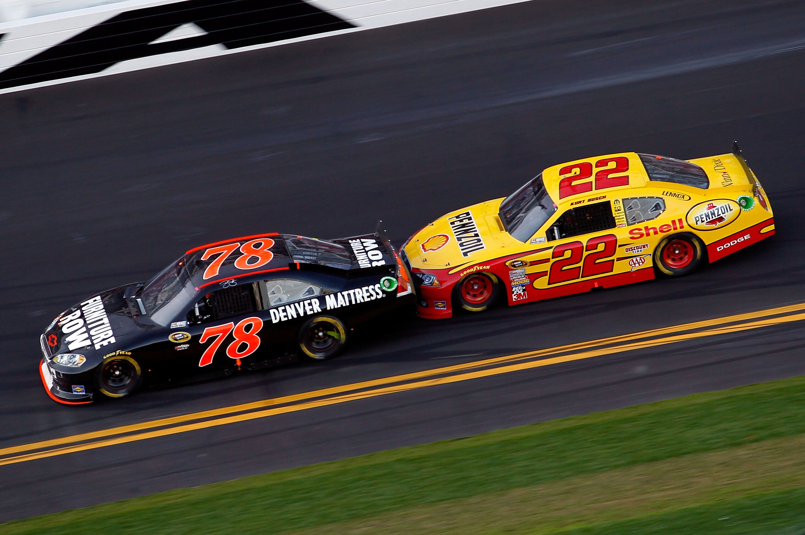 DAYTONA BEACH, FL - FEBRUARY 20:  Regan Smith, driver of the #78 Furniture Row Racing Chevrolet,  and Kurt Busch, driver of the #22 Shell Pennzoil Dodge, race during the NASCAR Sprint Cup Series Daytona 500 at Daytona International Speedway on February 20
