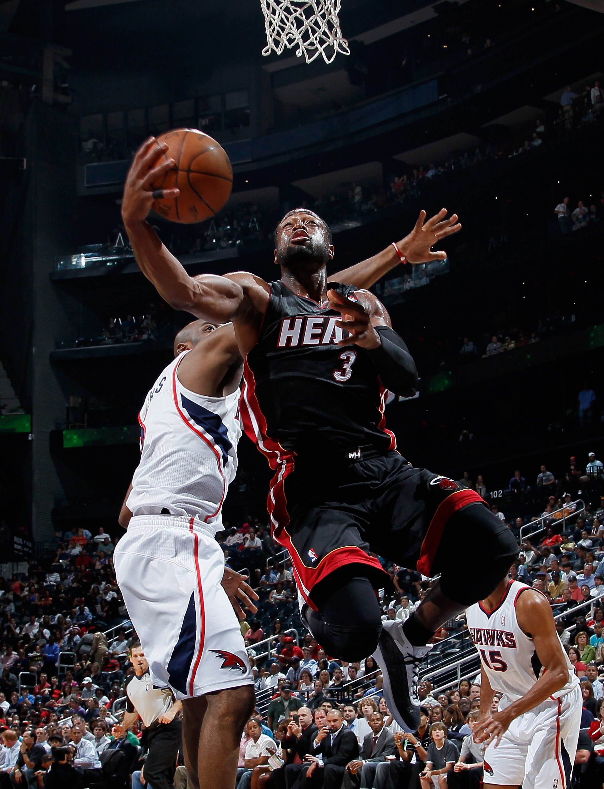 ATLANTA, GA - APRIL 11:  Dwyane Wade #3 of the Miami Heat lays in a basket against Damien Wilkins #3 of the Atlanta Hawks at Philips Arena on April 11, 2011 in Atlanta, Georgia.  NOTE TO USER: User expressly acknowledges and agrees that, by downloading an