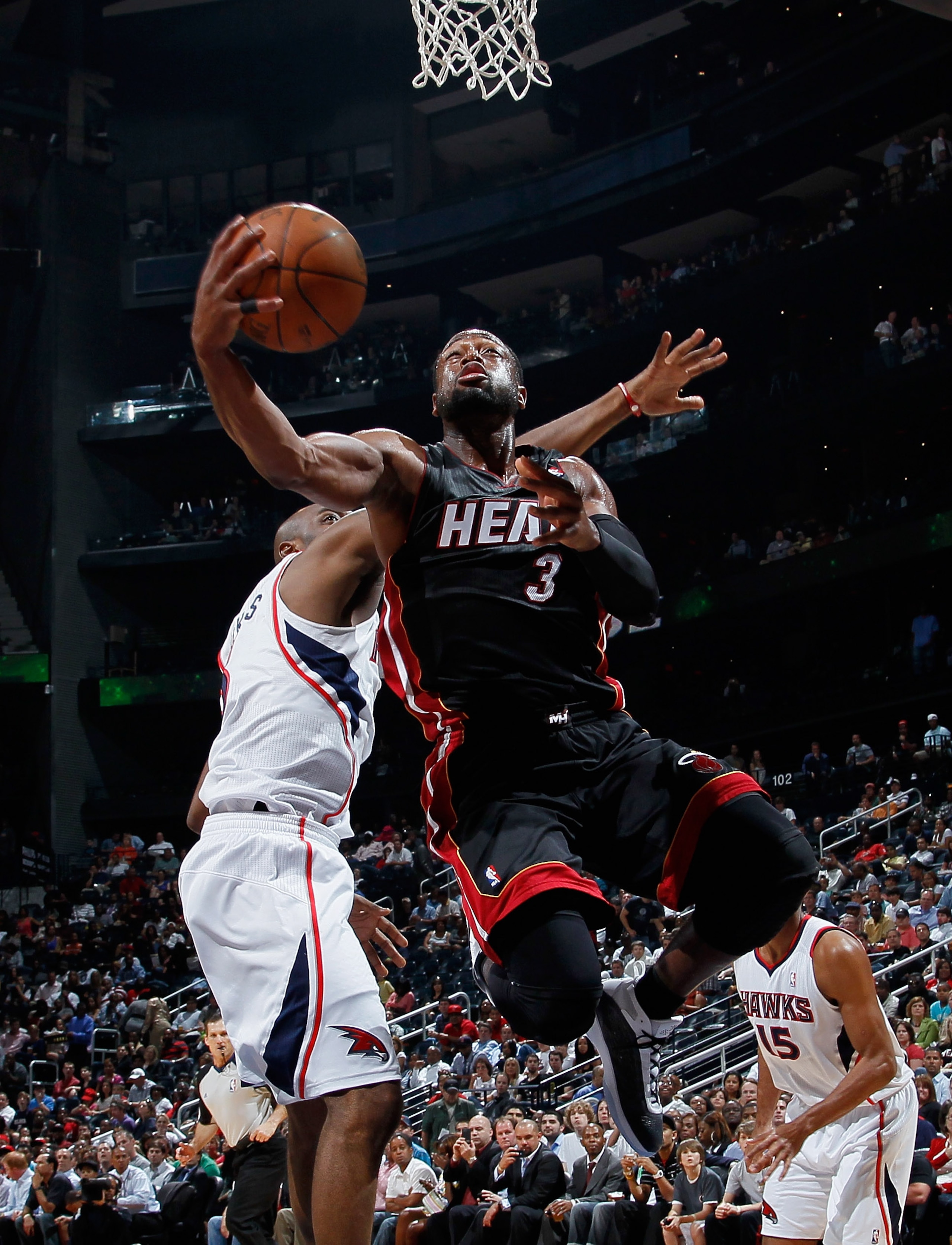 ATLANTA, GA - APRIL 11:  Dwyane Wade #3 of the Miami Heat lays in a basket against Damien Wilkins #3 of the Atlanta Hawks at Philips Arena on April 11, 2011 in Atlanta, Georgia.  NOTE TO USER: User expressly acknowledges and agrees that, by downloading an