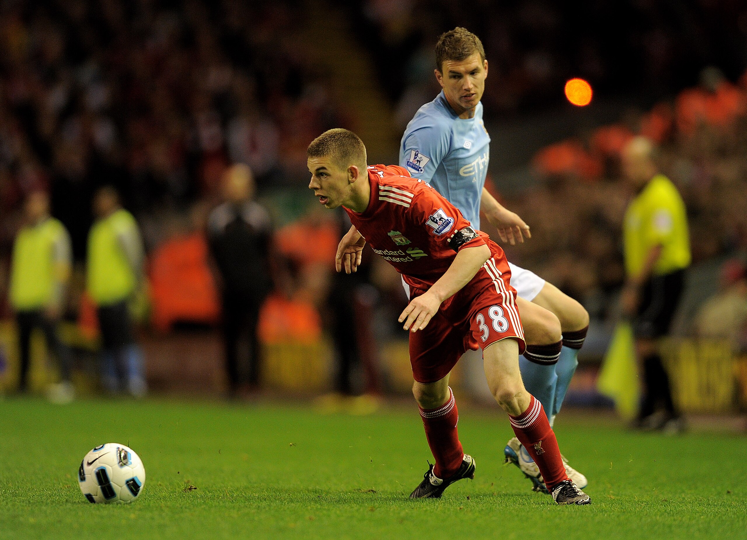 LIVERPOOL, ENGLAND - APRIL 11:   John Flanagan of Liverpool competes with Edin Dzeko of Manchester City during the Barclays Premier League match between Liverpool and Manchester City at Anfield on April 11, 2011 in Liverpool, England. (Photo by Michael Re