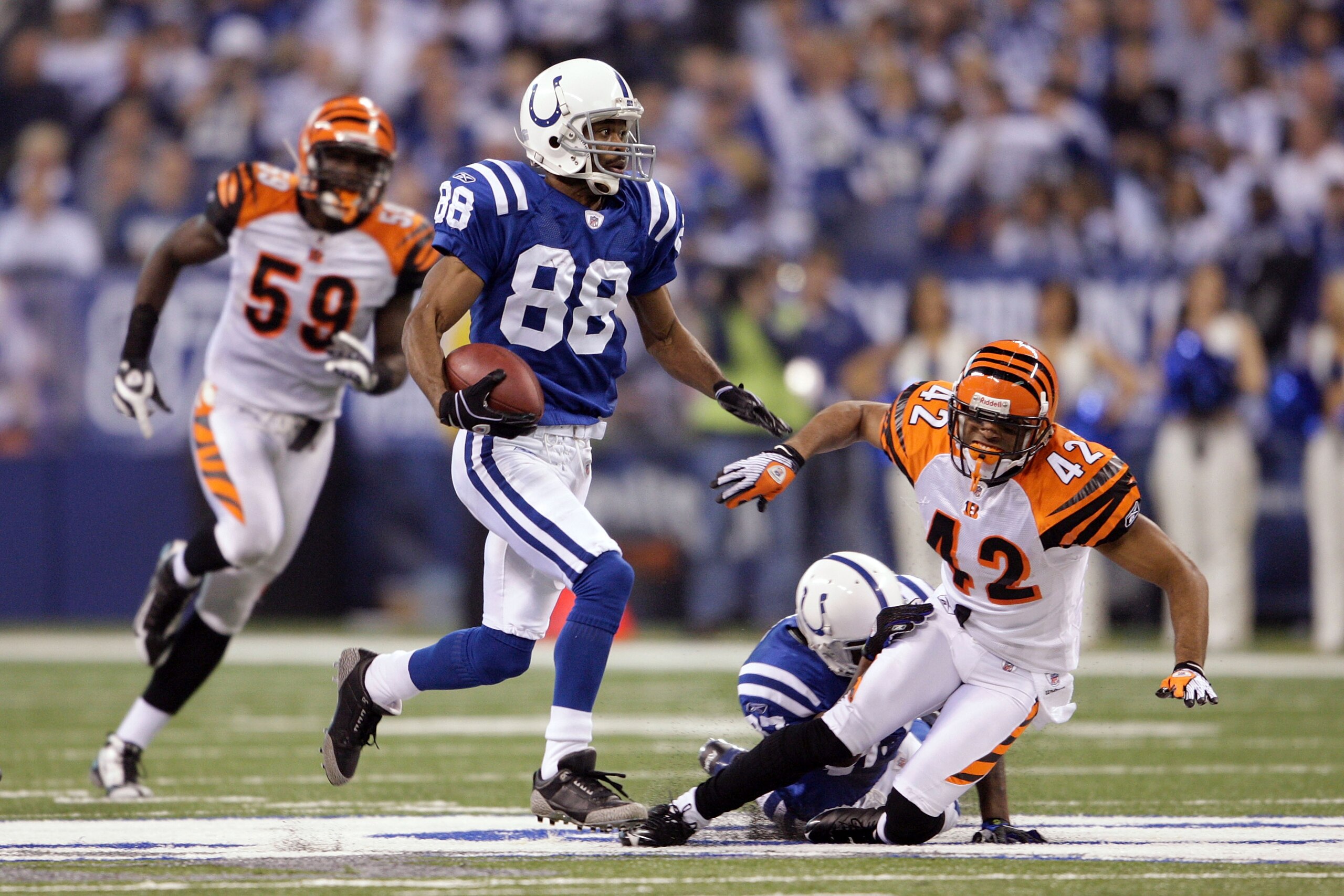 INDIANAPOLIS - DECEMBER 07:  Marvin Harrison #88 of the Indianapolis Colts runs for yards after the catch on a 67-yard reception in the third quarter against Chris Crocker #42 and Brandon Johnson #59 of the Cincinnati Bengals at Lucas Oil Stadium on Decem