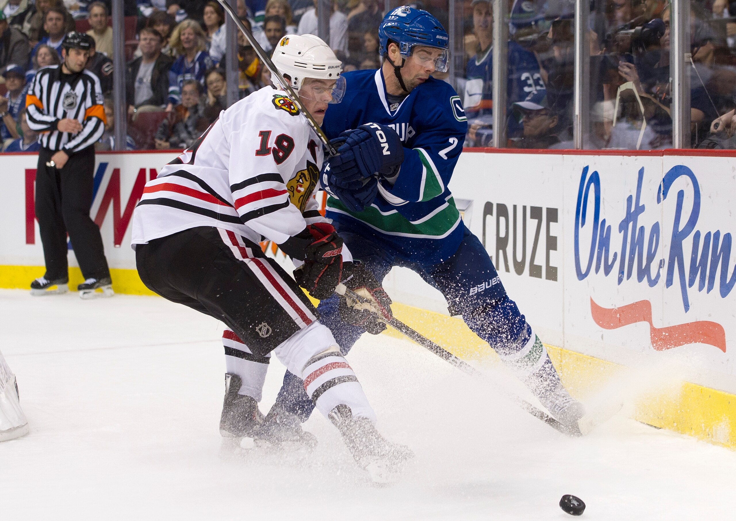 VANCOUVER, CANADA - APRIL 13: Dan Hamhuis #2 of the Vancouver Canucks gets his stick high on Jonathan Toews #19 of the Chicago Blackhawks while battling for the loose puck during the third period in Game One of the Western Conference Quarterfinals during