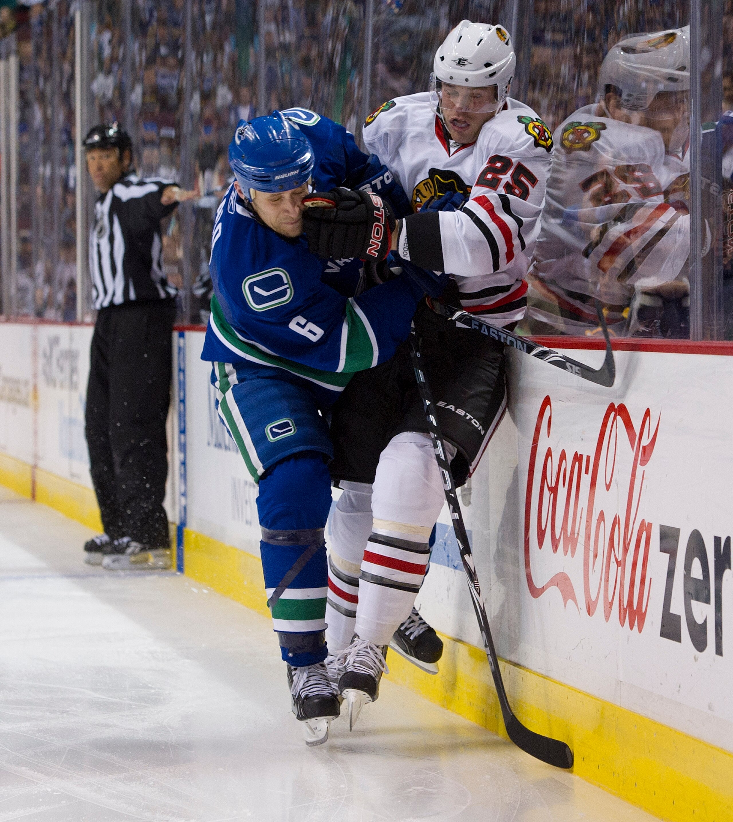 VANCOUVER, CANADA - APRIL 13: Sami Salo #6 of the Vancouver Canucks checks Viktor Stalberg #25 of the Chicago Blackhawks along the side boards during the second period in Game One of the Western Conference Quarterfinals during the 2011 NHL Stanley Cup Pla