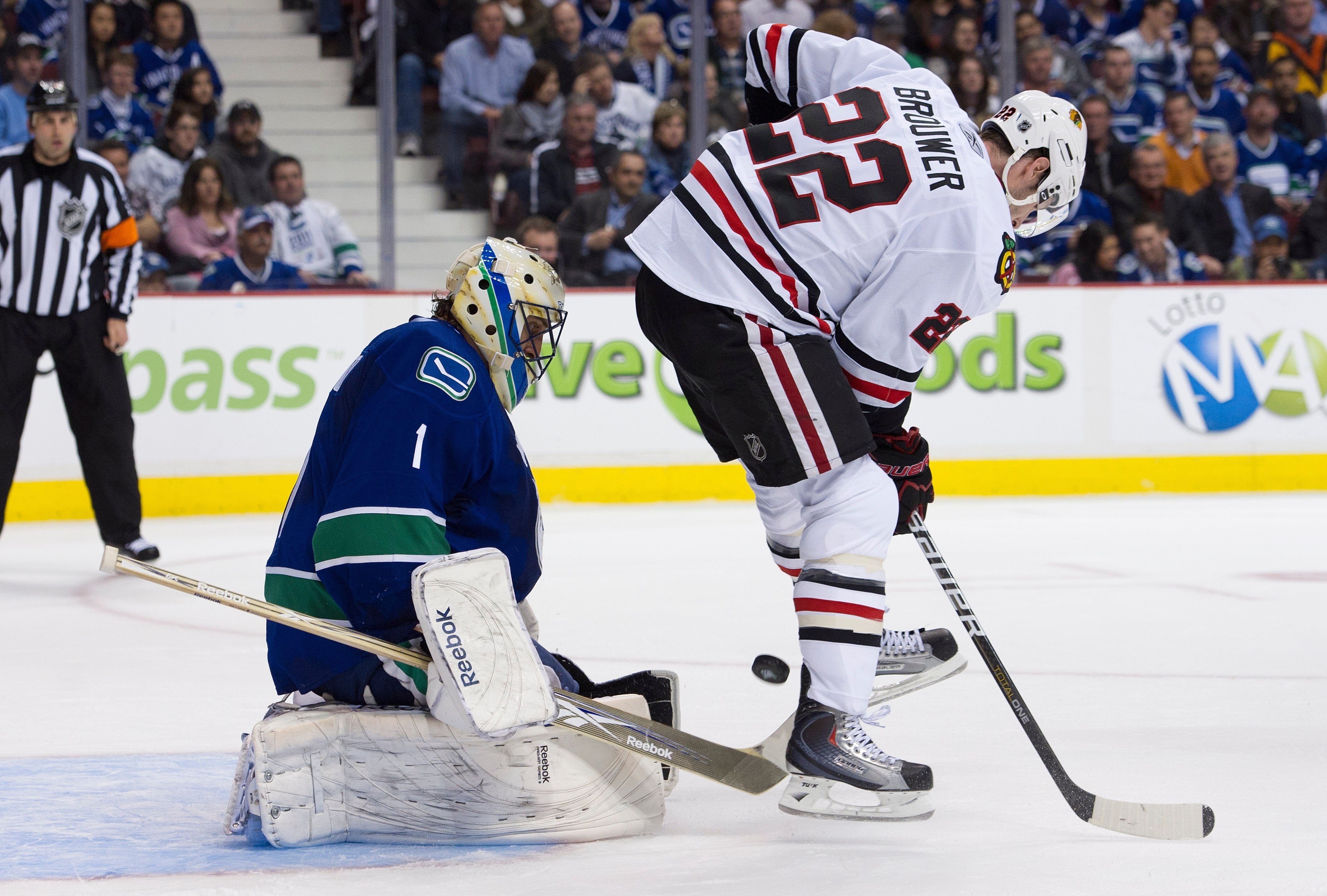 VANCOUVER, CANADA - APRIL 13: Troy Brouwer #22 of the Chicago Blackhawks tries to deflect the puck past goalie Roberto Luongo #1 of the Vancouver Canucks during the second period in Game One of the Western Conference Quarterfinals during the 2011 NHL Stan
