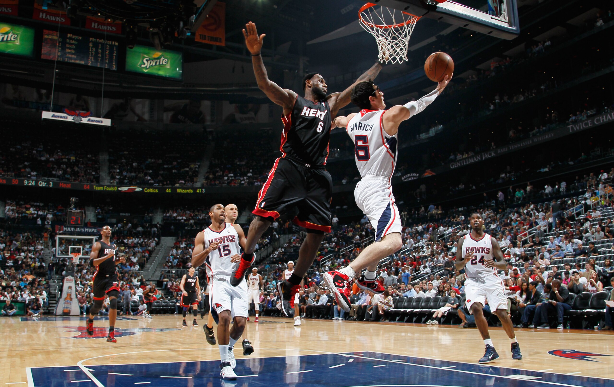 ATLANTA, GA - APRIL 11:  Kirk Hinrich #6 of the Atlanta Hawks lays in a basket against LeBron James #6 of the Miami Heat at Philips Arena on April 11, 2011 in Atlanta, Georgia.  NOTE TO USER: User expressly acknowledges and agrees that, by downloading and