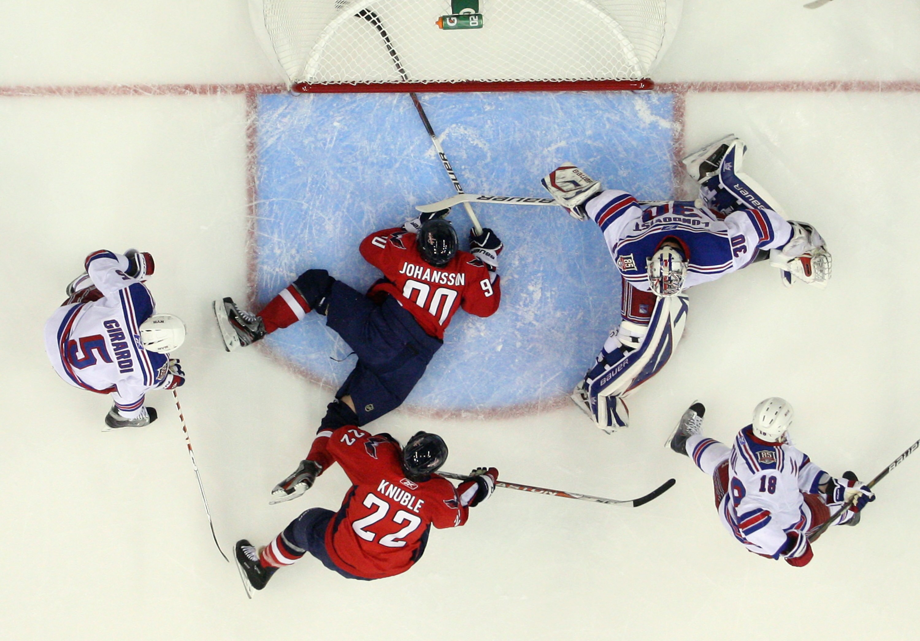 WASHINGTON, DC - APRIL 13:  Marcus Johansson #90 of the Washington Capitals lands in the crease as Henrik Lundqvist #30 of the New York Rangers tends net in Game One of the Eastern Conference Quarterfinals during the 2011 NHL Stanley Cup Playoffs at Veriz