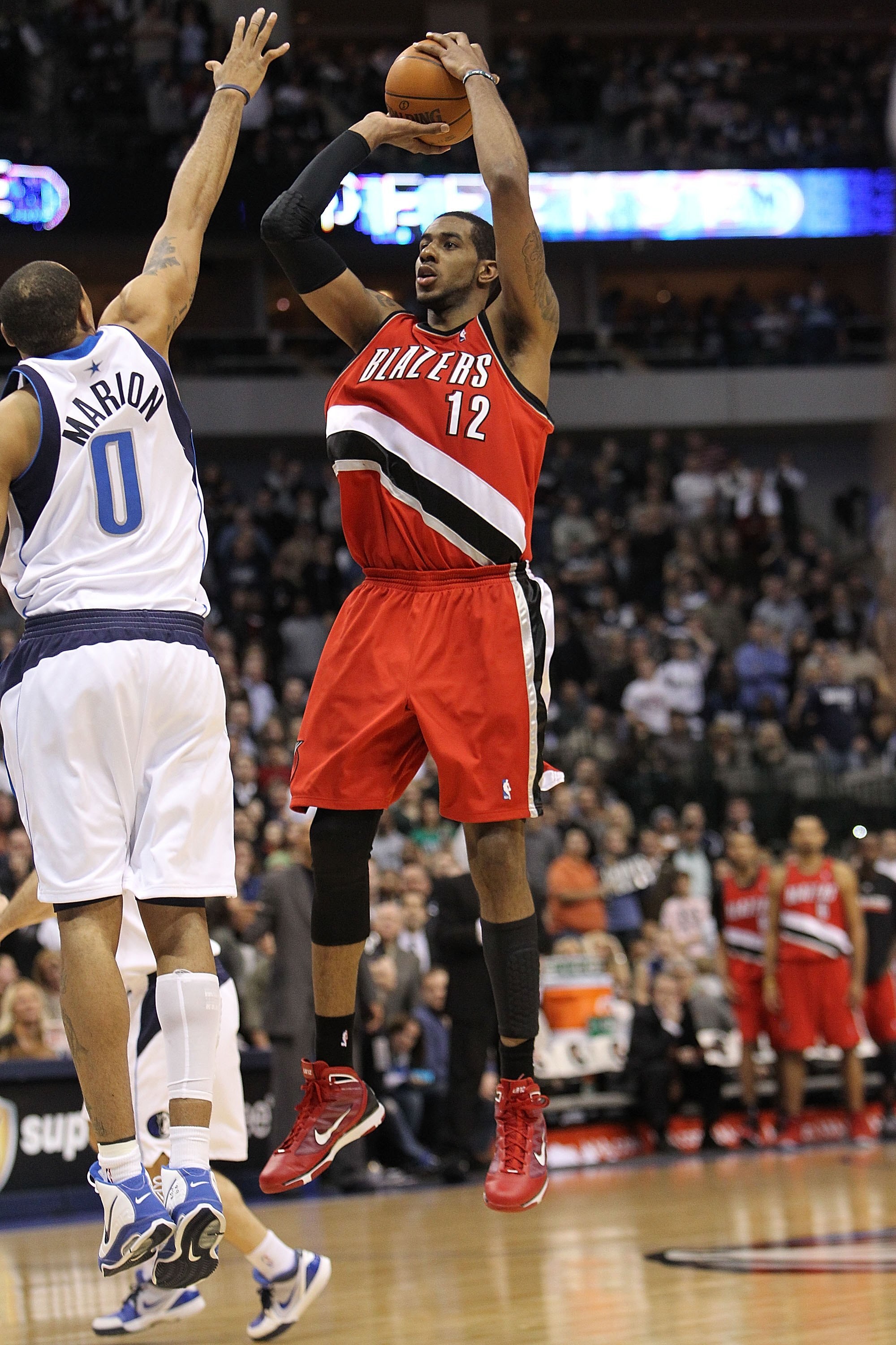 DALLAS - JANUARY 30:  Forward LaMarcus Aldridge #12 of the Portland Trail Blazers takes a shot against Shawn Marion #0 of the Dallas Mavericks on January 30, 2010 at American Airlines Center in Dallas, Texas.  NOTE TO USER: User expressly acknowledges and