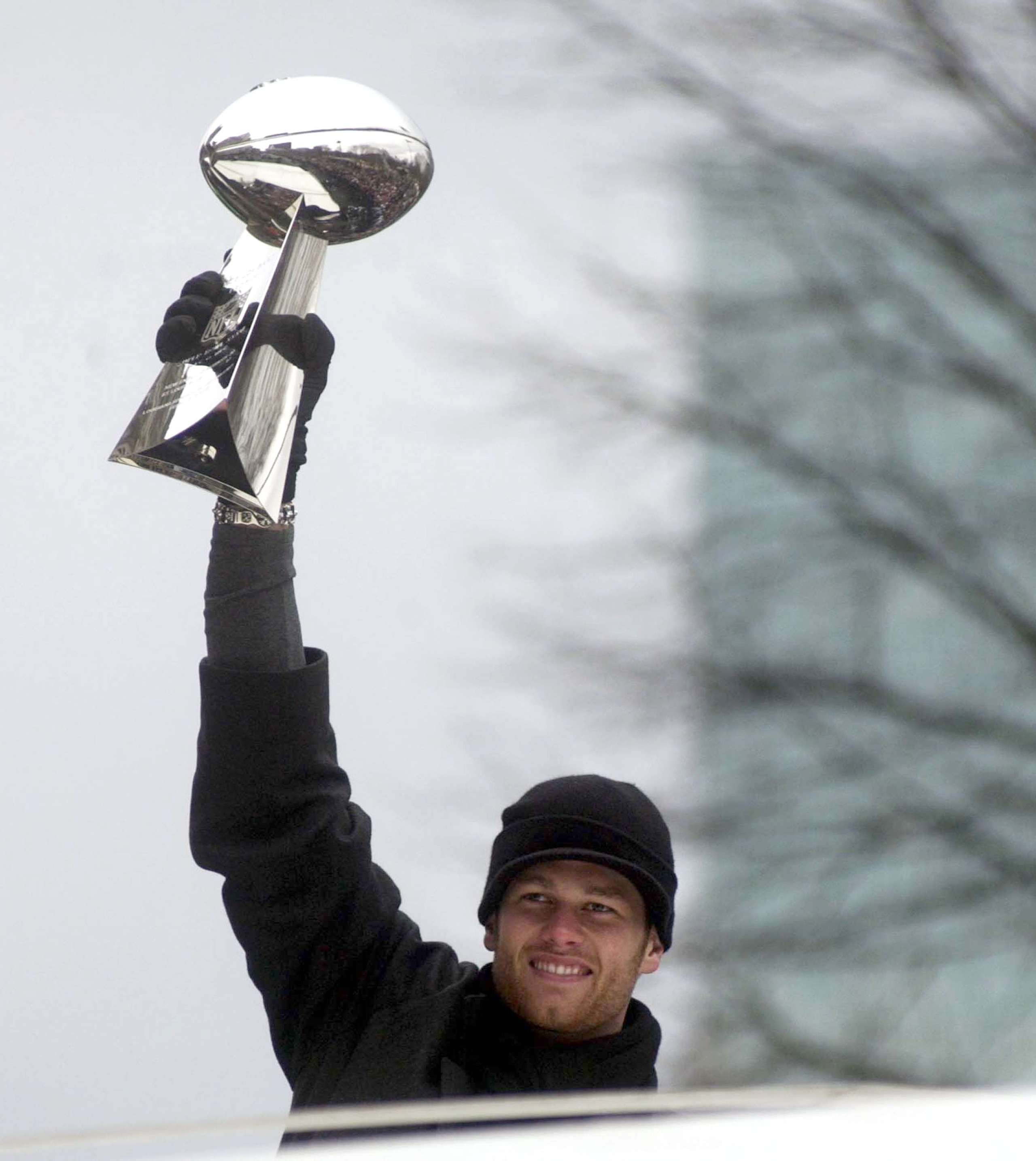 BOSTON, MA - FEBRUARY 3:  New England Patriots quarterback Tom Brady hoists the Lombardi Trophy during a victory parade February 3, 2004 in Boston, Massachusetts. The Patriots celebrated their second championship in three years today with a parade through