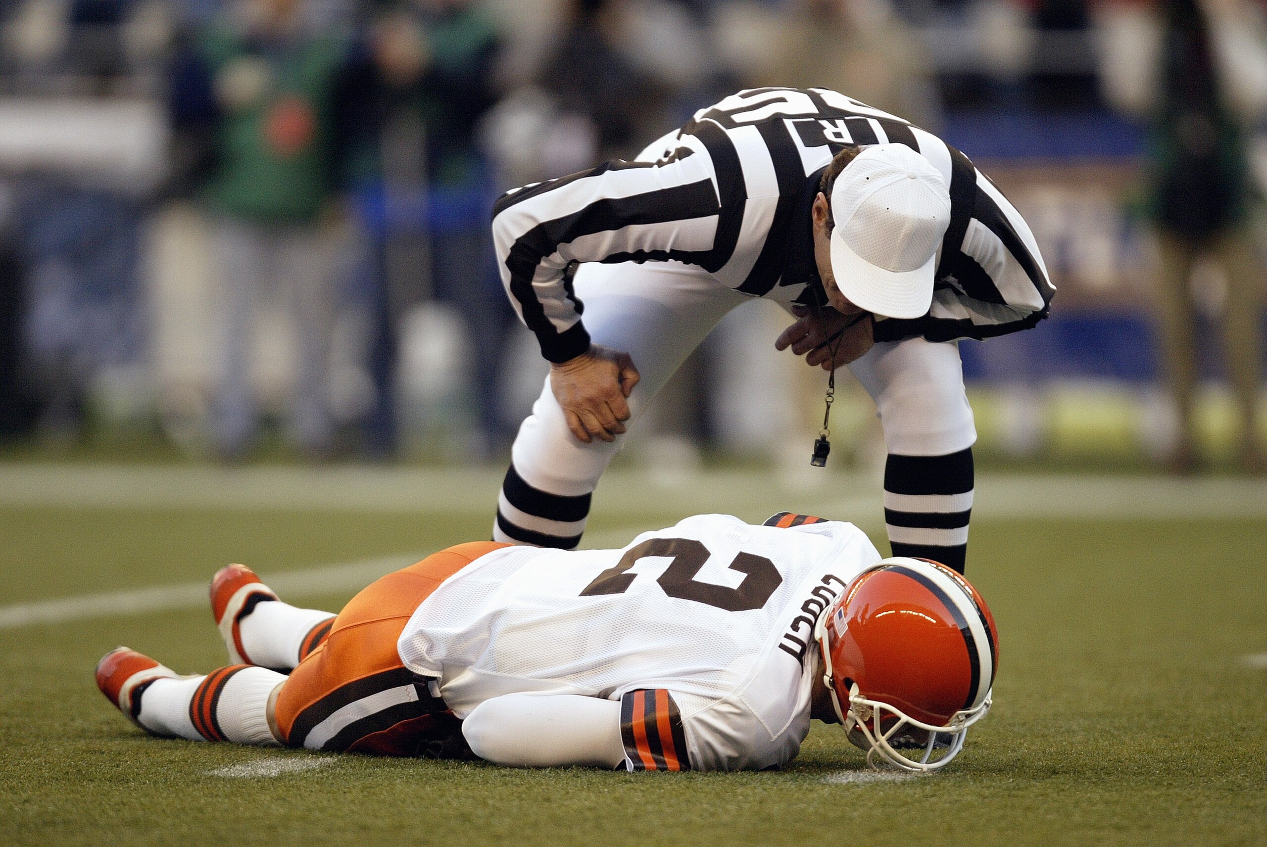 SEATTLE - NOVEMBER 30:  Referee Ed Hochuli #85 looks to help Quarterback Tim Couch #2 of the Cleveland Browns as he lays hurt during the game against the Seattle Seahawks on November 30 2003 at Seahawks Stadium in Seattle, Washington. The Seahawks defeate
