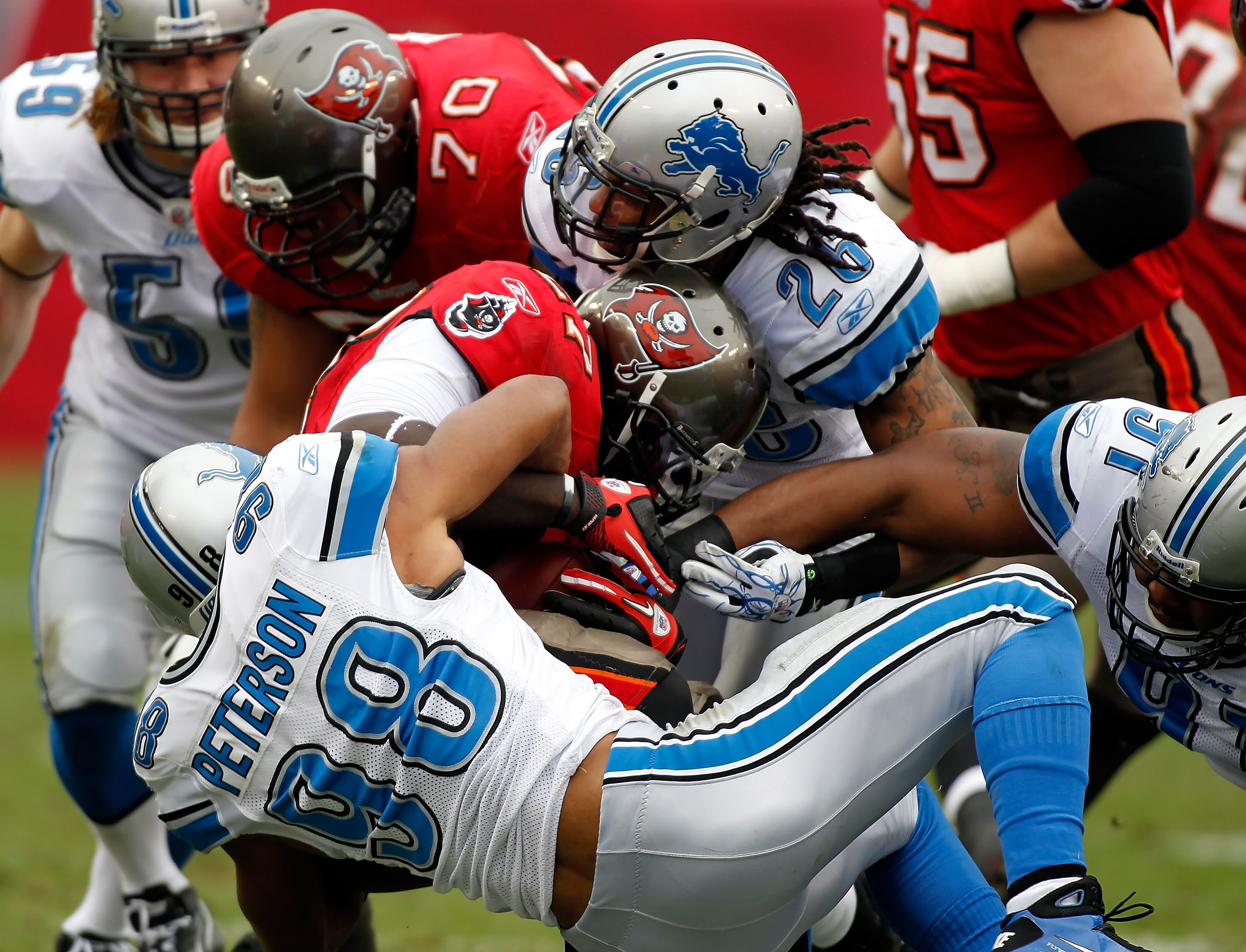 TAMPA, FL - DECEMBER 19:  Running  back LeGarrette Blount #27 of the Tampa Bay Buccaneers is tackled by defensive tackle Julian Peterson #98 of the Detroit Lions during the game at Raymond James Stadium on December 19, 2010 in Tampa, Florida.  (Photo by J