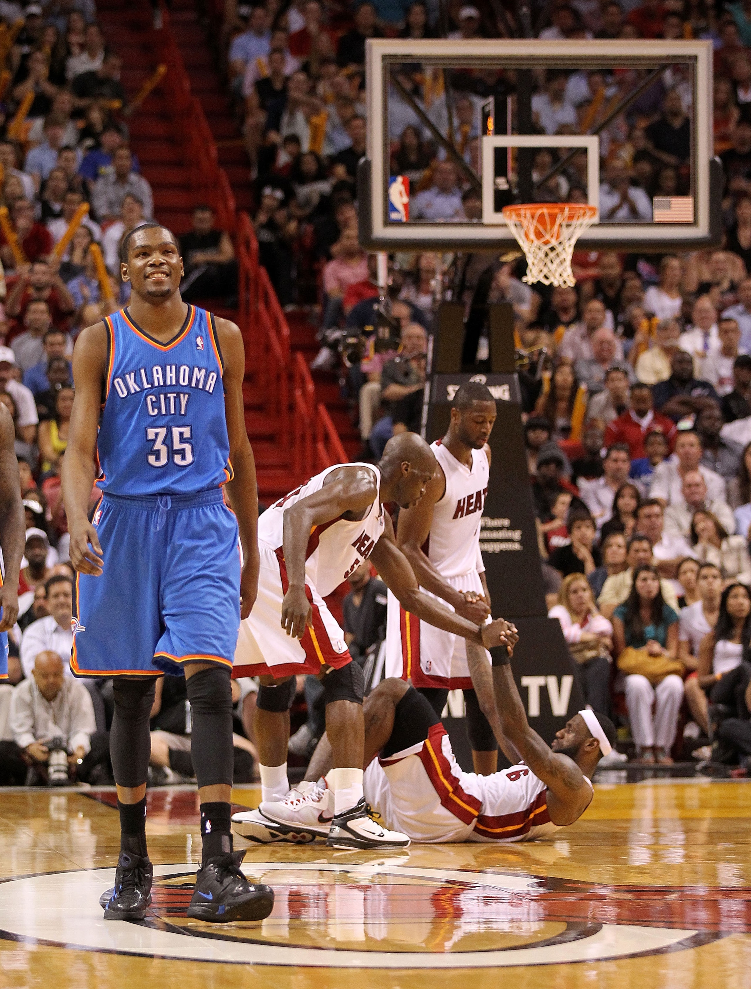 MIAMI, FL - MARCH 16:  Kevin Durant #35  of the the Oklahoma City Thunder walks up the floor after committing an offensive foul as LeBron James #6 of the Miami Heat is helped up by Dwyane Wade #3 and Joel Anthony #50 during a game at American Airlines Are