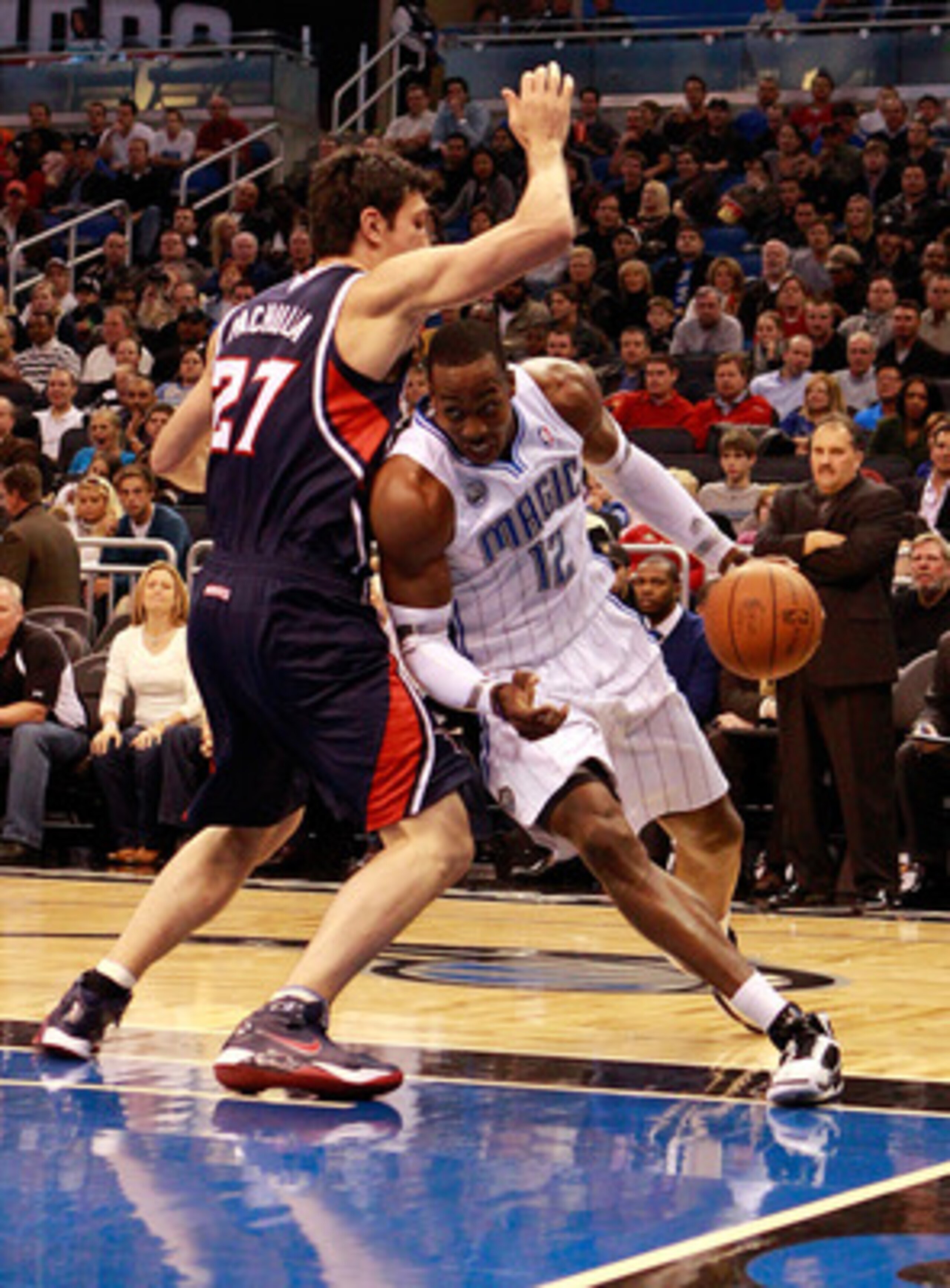 ORLANDO, FL - DECEMBER 06:  Dwight Howard #12 of the Orlando Magic drives against Zaza Pachulia #27 of the Atlanta Hawks during the game at Amway Arena on December 6, 2010 in Orlando, Florida. NOTE TO USER: User expressly acknowledges and agrees that, by 