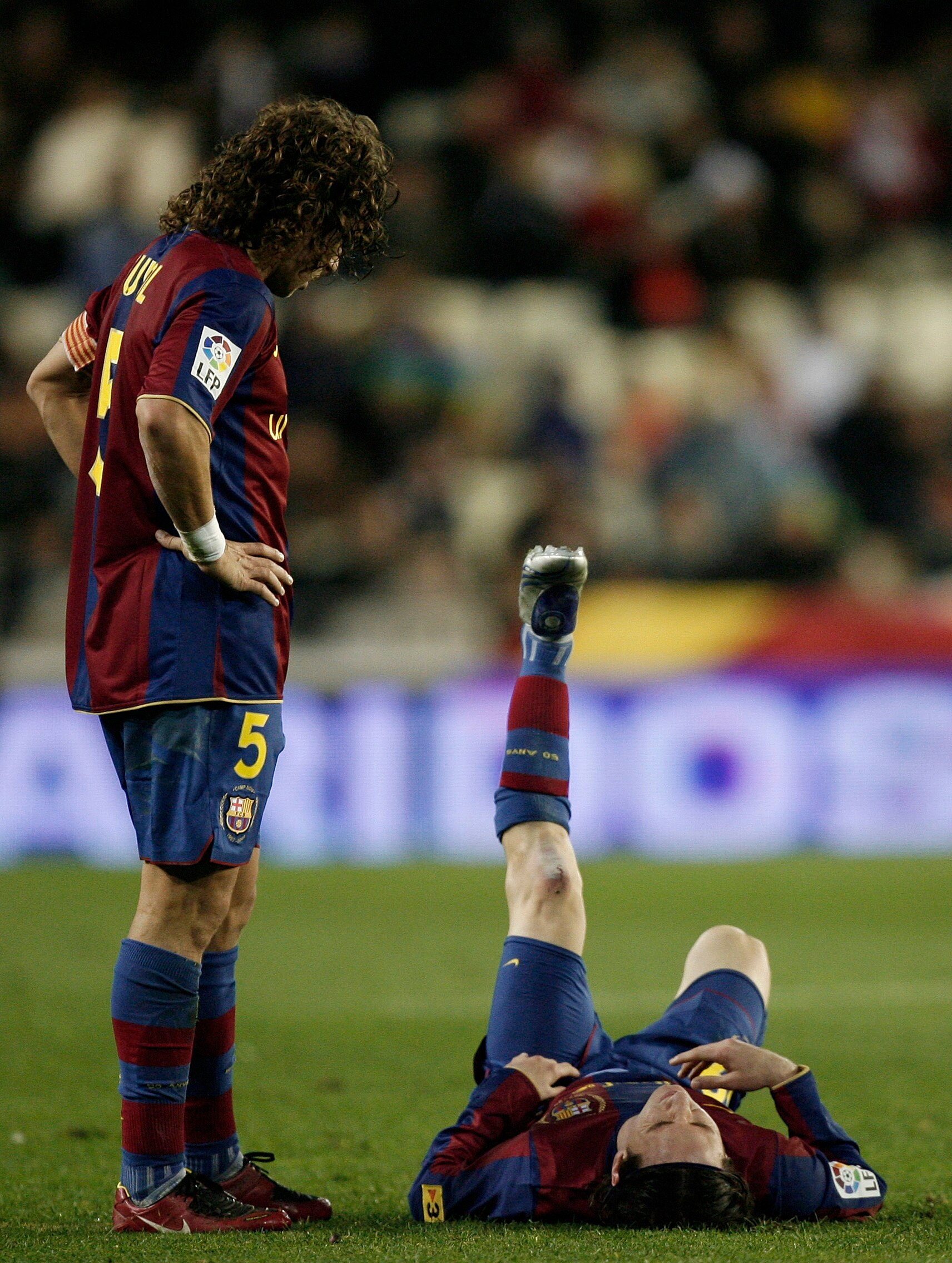 VALENCIA, SPAIN - DECEMBER 15:  Carles Puyol (L) of Barcelona looks at his injured teammate Lionel Messi laying on the pitch before abandoning the match during the La Liga match between Valencia and Barcelona at the Mestalla Stadium December 15, 2007 in V