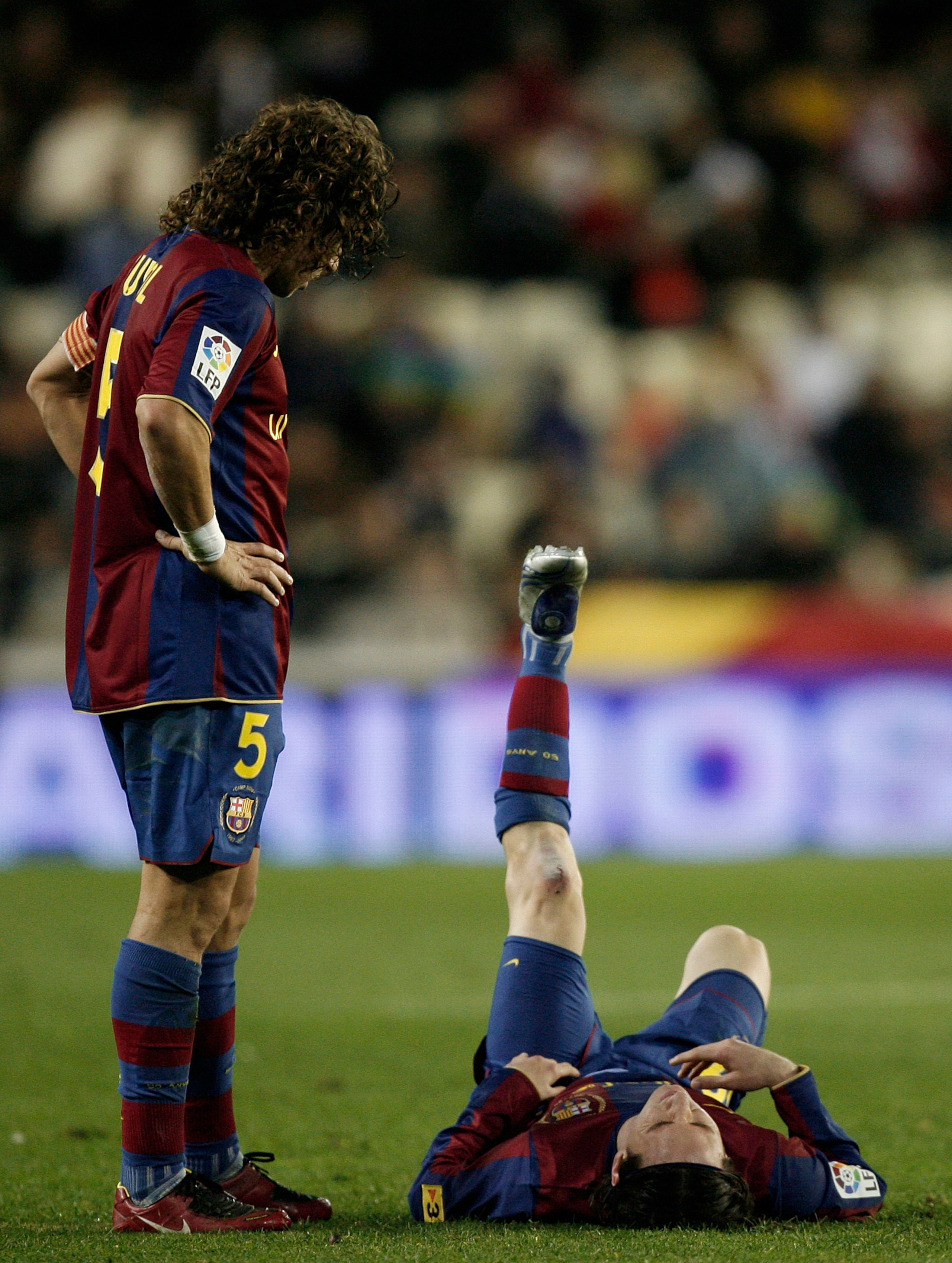 VALENCIA, SPAIN - DECEMBER 15:  Carles Puyol (L) of Barcelona looks at his injured teammate Lionel Messi laying on the pitch before abandoning the match during the La Liga match between Valencia and Barcelona at the Mestalla Stadium December 15, 2007 in V