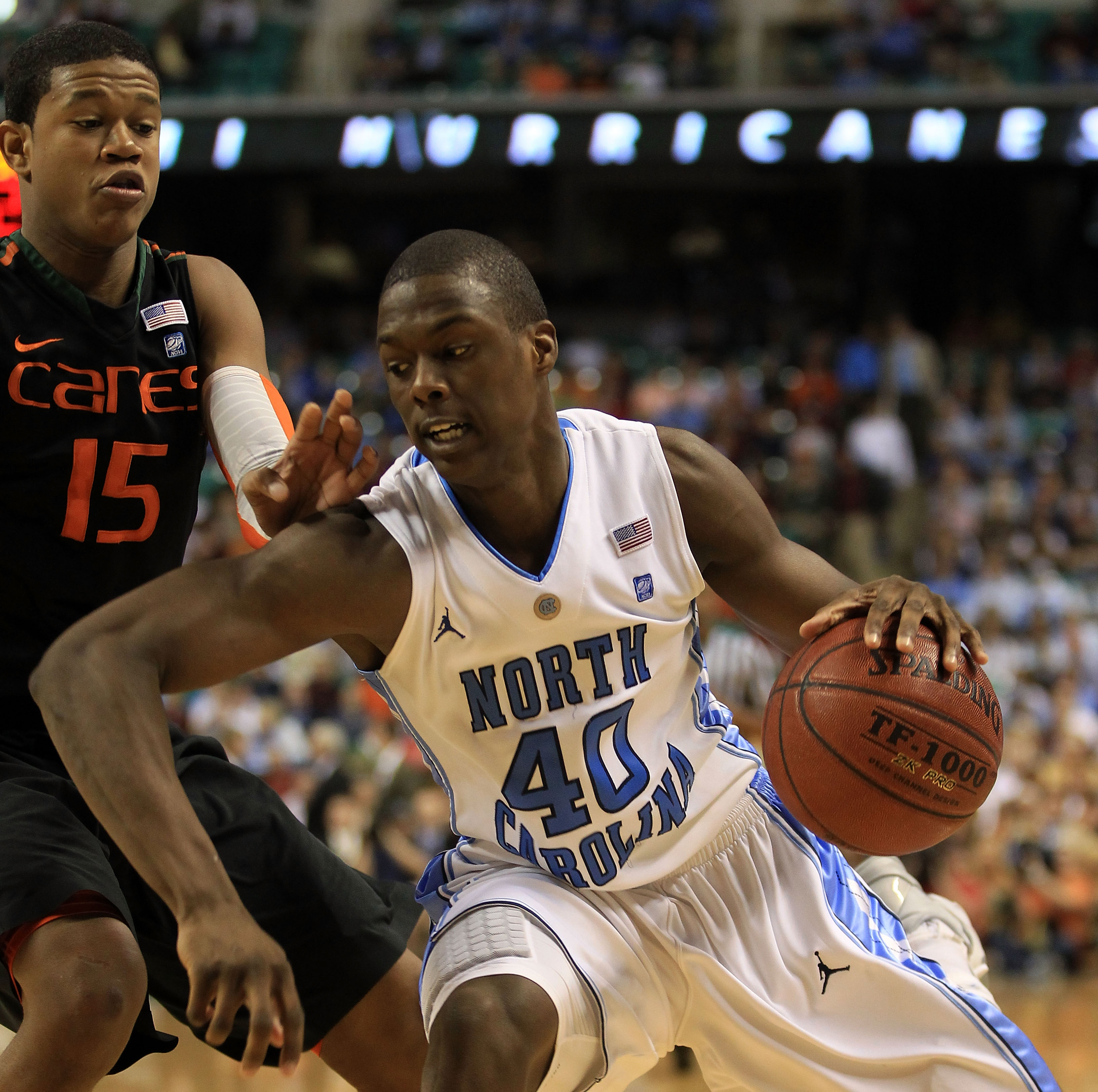 GREENSBORO, NC - MARCH 11:  Harrison Barnes #40 of the North Carolina Tar Heels drives against Rion Brown #15 of the Miami Hurricanes during the second half in the quarterfinals of the 2011 ACC men's basketball tournament at the Greensboro Coliseum on Mar