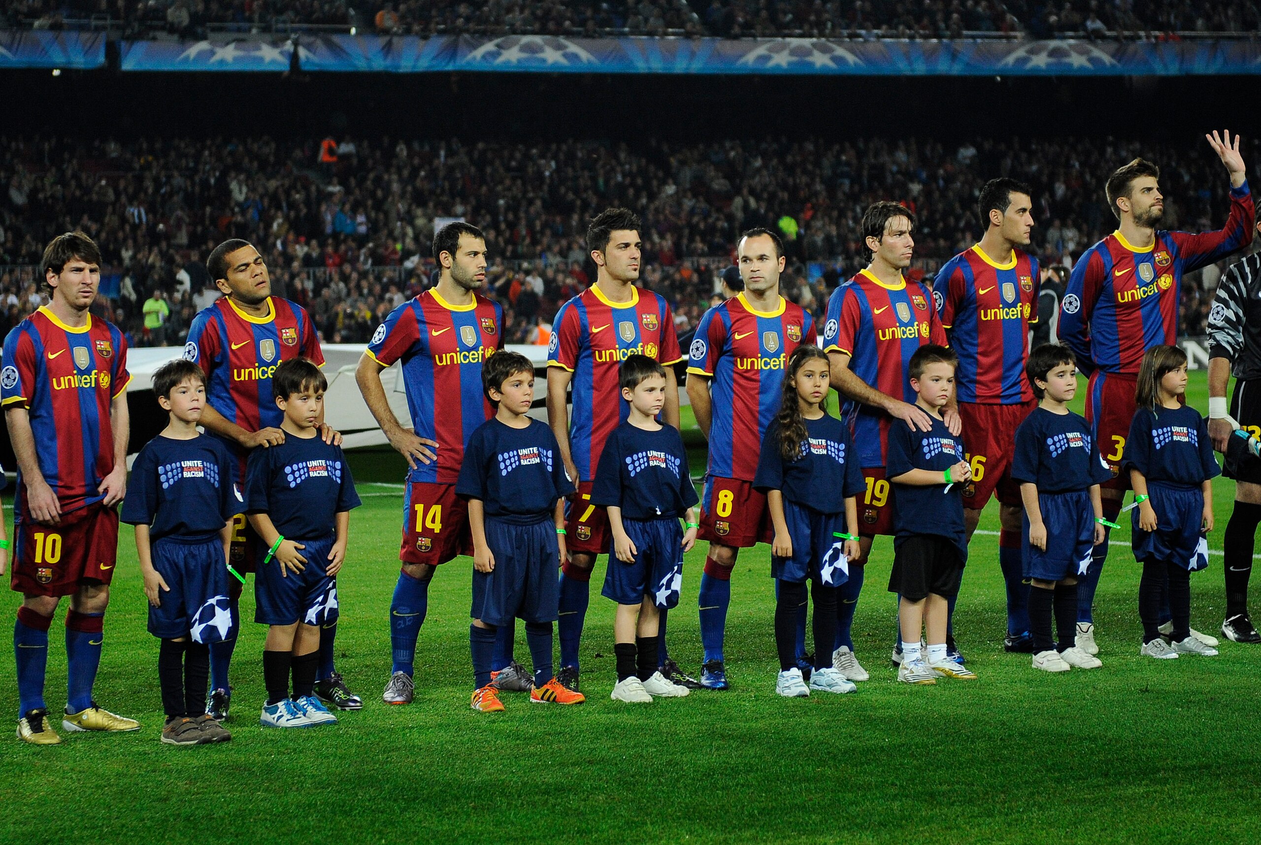 BARCELONA, SPAIN - OCTOBER 20:  Children wearing 'United against Racism T-shirts' pose with Barcelona players prior the start of the UEFA Champions League group D match between Barcelona and FC Copenhagen at the Camp nou stadium on October 20, 2010 in Bar