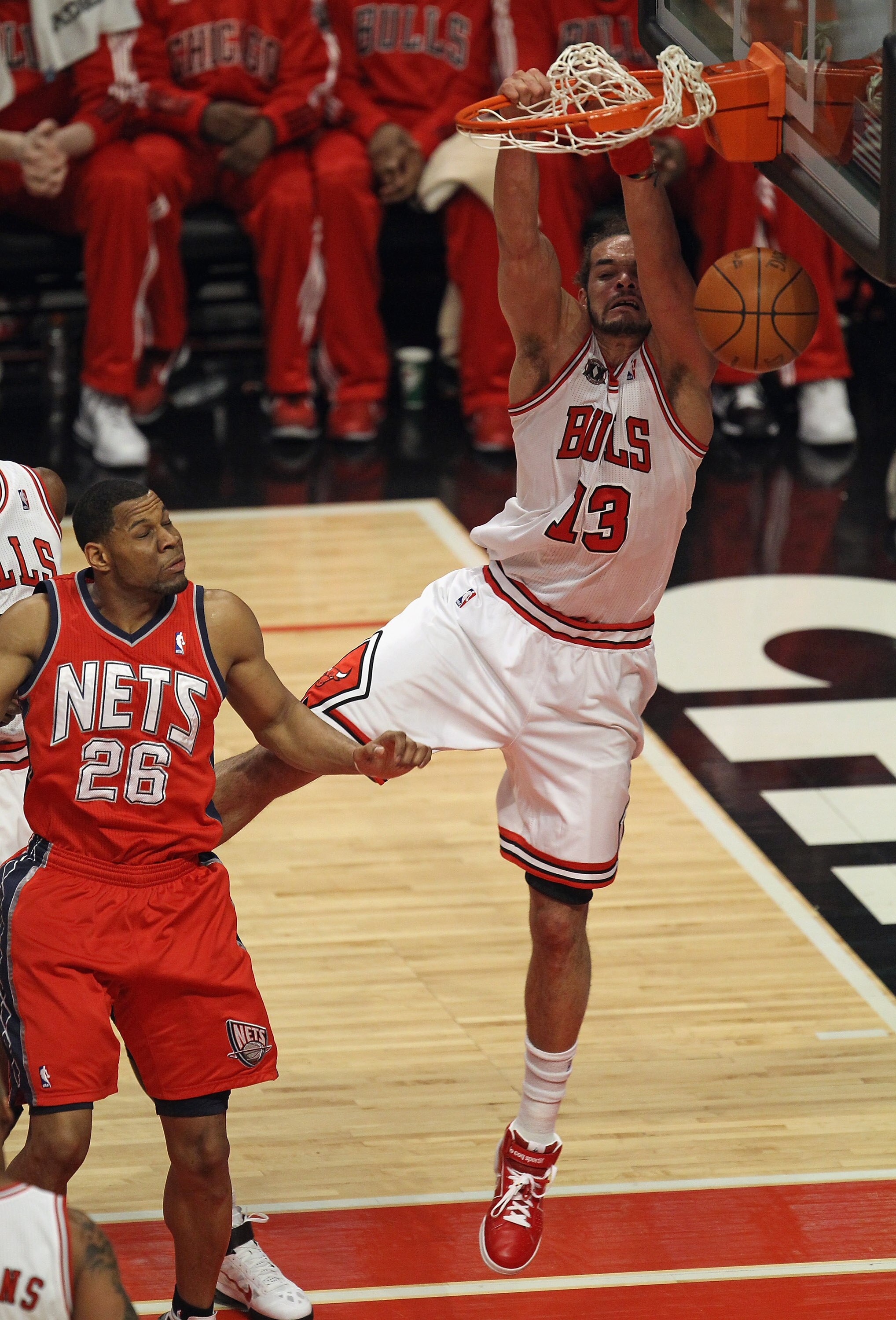 CHICAGO, IL - APRIL 13: Joakim Noah #13 of the Chicago Bulls dunks the ball over Stephen Graham #26 of the New Jersey Nets at United Center on April 13, 2011 in Chicago, Illinois. NOTE TO USER: User expressly acknowledges and agress that, by downloading a