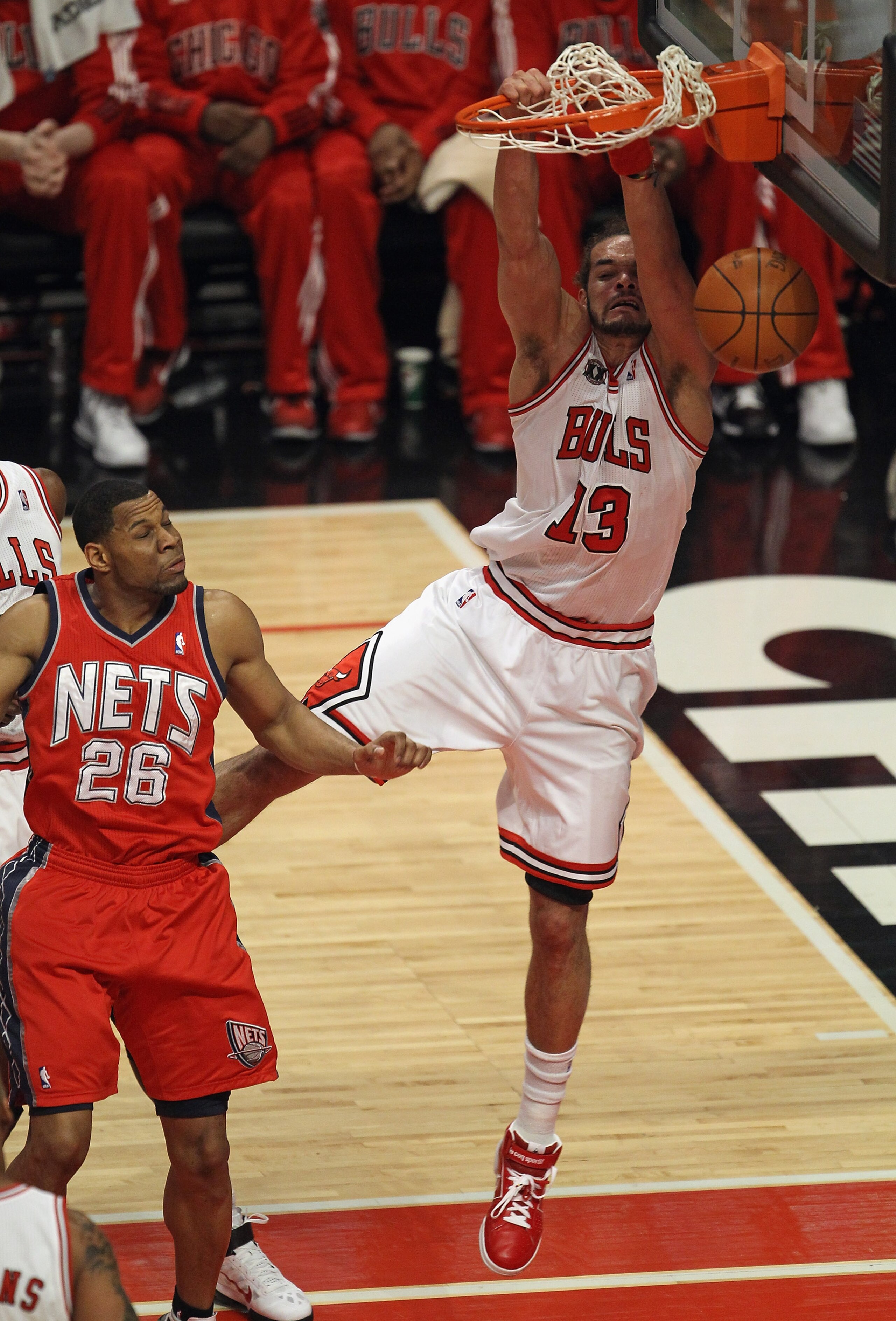 CHICAGO, IL - APRIL 13: Joakim Noah #13 of the Chicago Bulls dunks the ball over Stephen Graham #26 of the New Jersey Nets at United Center on April 13, 2011 in Chicago, Illinois. NOTE TO USER: User expressly acknowledges and agress that, by downloading a