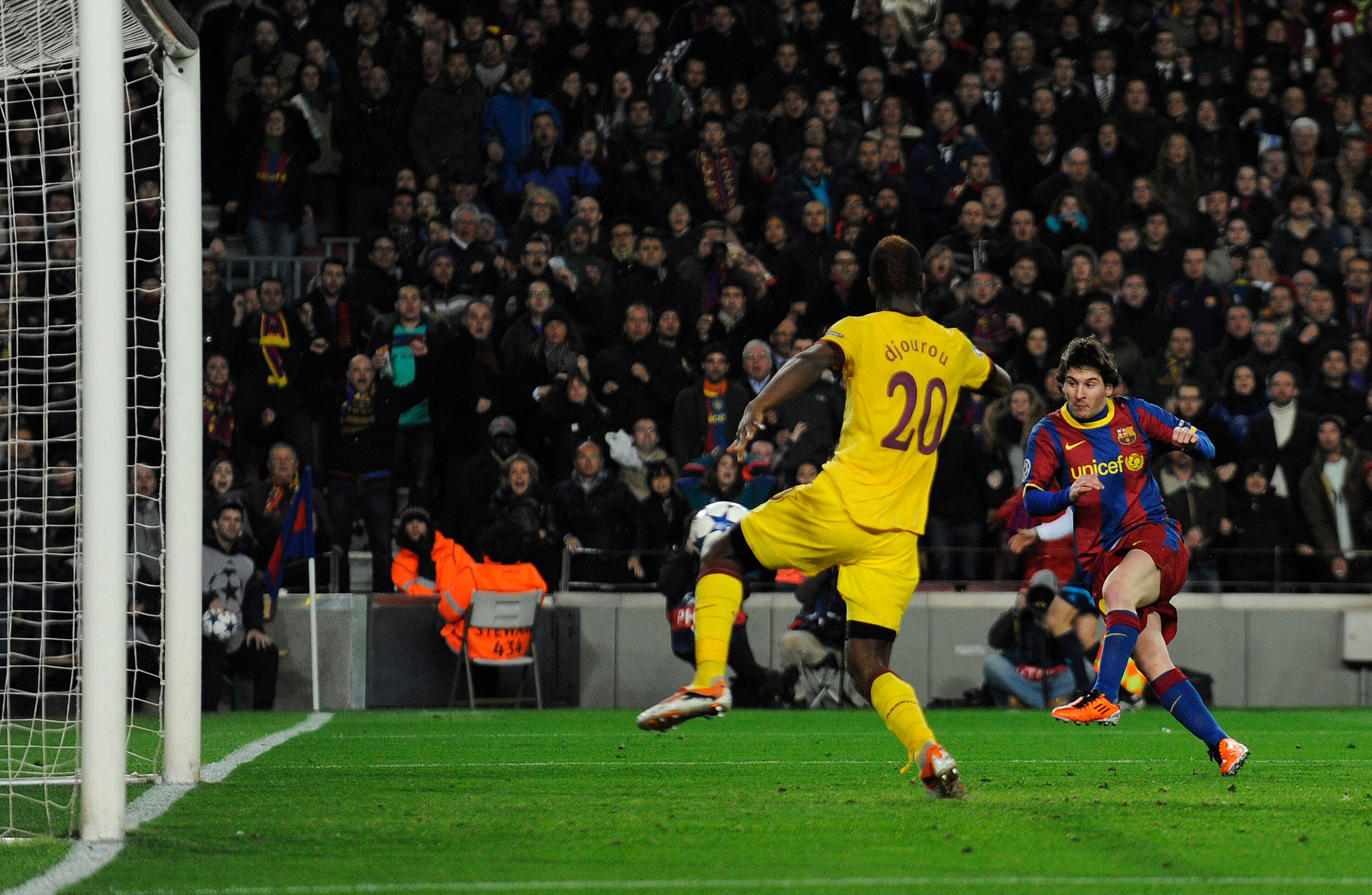 BARCELONA, SPAIN - MARCH 08:  Lionel Messi of FC Barcelona (R) scores his first team's side goal under a chanllenge by Johan Djourou of Arsenal during the UEFA Champions League round of 16 second leg match between Barcelona and Arsenal at the Camp Nou sta