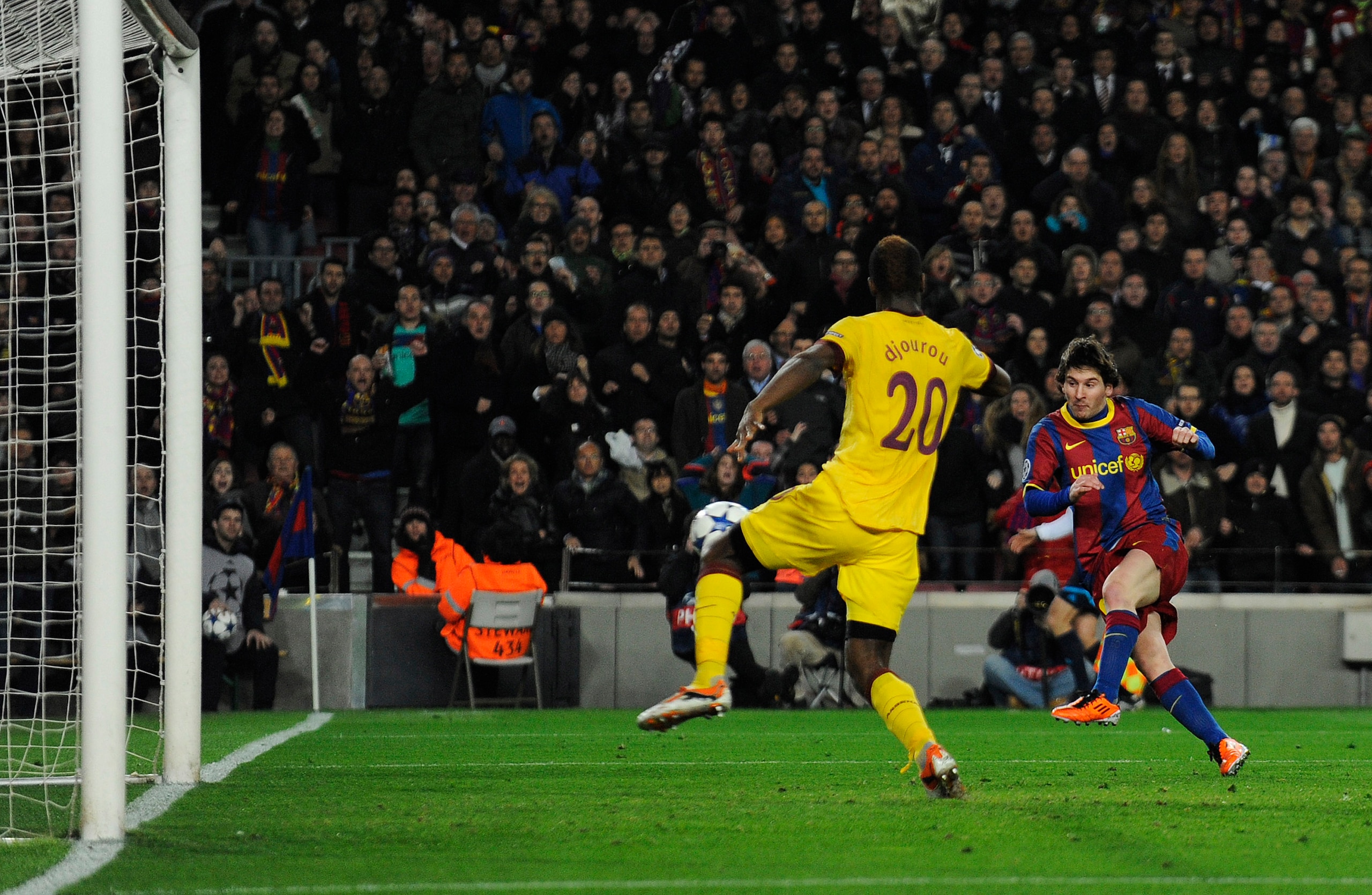 BARCELONA, SPAIN - MARCH 08: Lionel Messi of FC Barcelona (R) scores his first team's side goal under a chanllenge by Johan Djourou of Arsenal during the UEFA Champions League round of 16 second leg match between Barcelona and Arsenal at the Camp Nou sta BARCELONA, SPAIN - MARCH 08: Lionel Messi of FC Barcelona (R) scores his first team's side goal under a chanllenge by Johan Djourou of Arsenal during the UEFA Champions League round of 16 second leg match between Barcelona and Arsenal at the Camp Nou sta