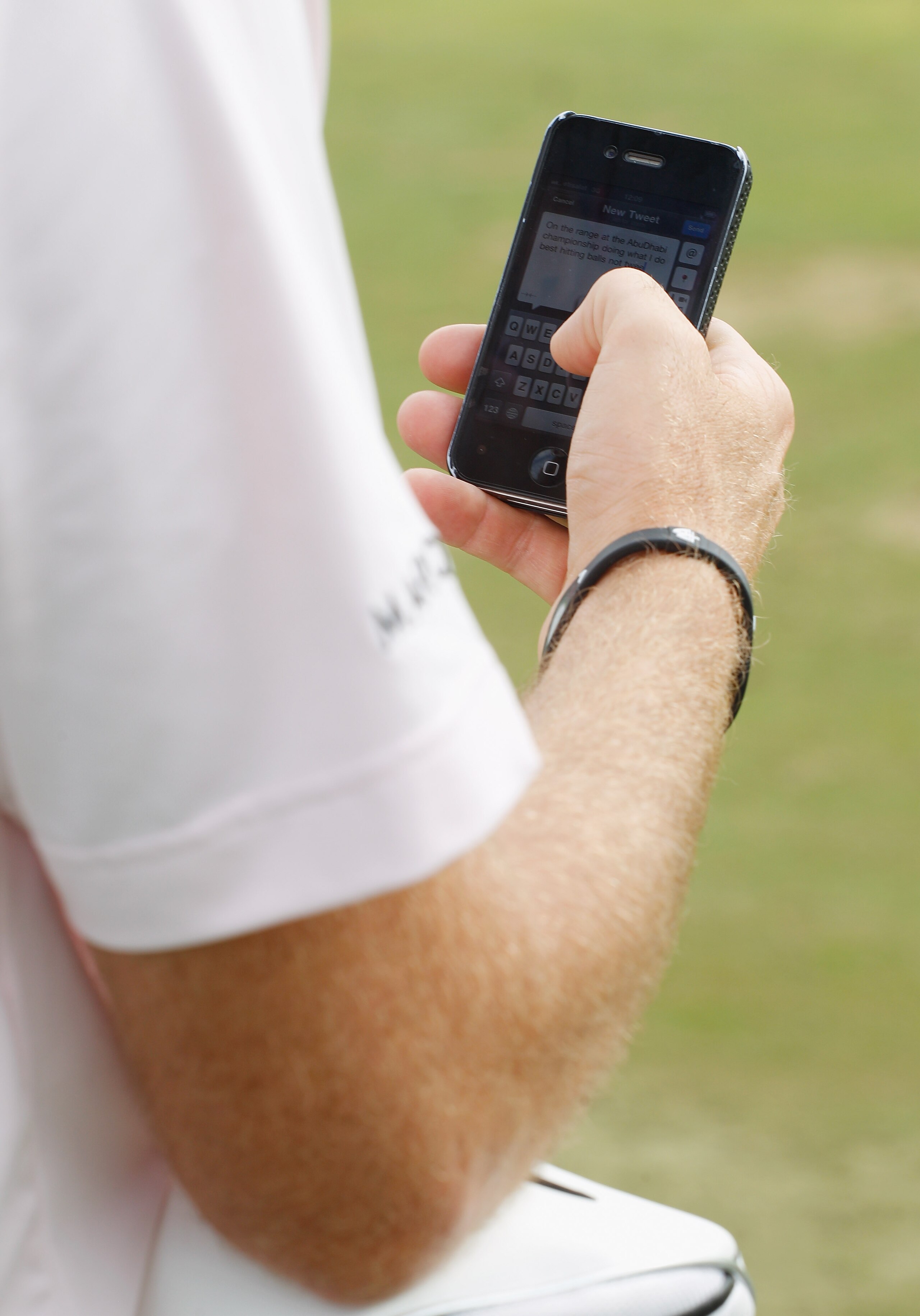ABU DHABI, UNITED ARAB EMIRATES - JANUARY 23:  Ian Poulter of England sends a message on Twitter on the practice ground during the final round of the 2011 Abu Dhabi HSBC Golf Championship at the Abu Dhabi Golf Club on January 23, 2011 in Abu Dhabi, United