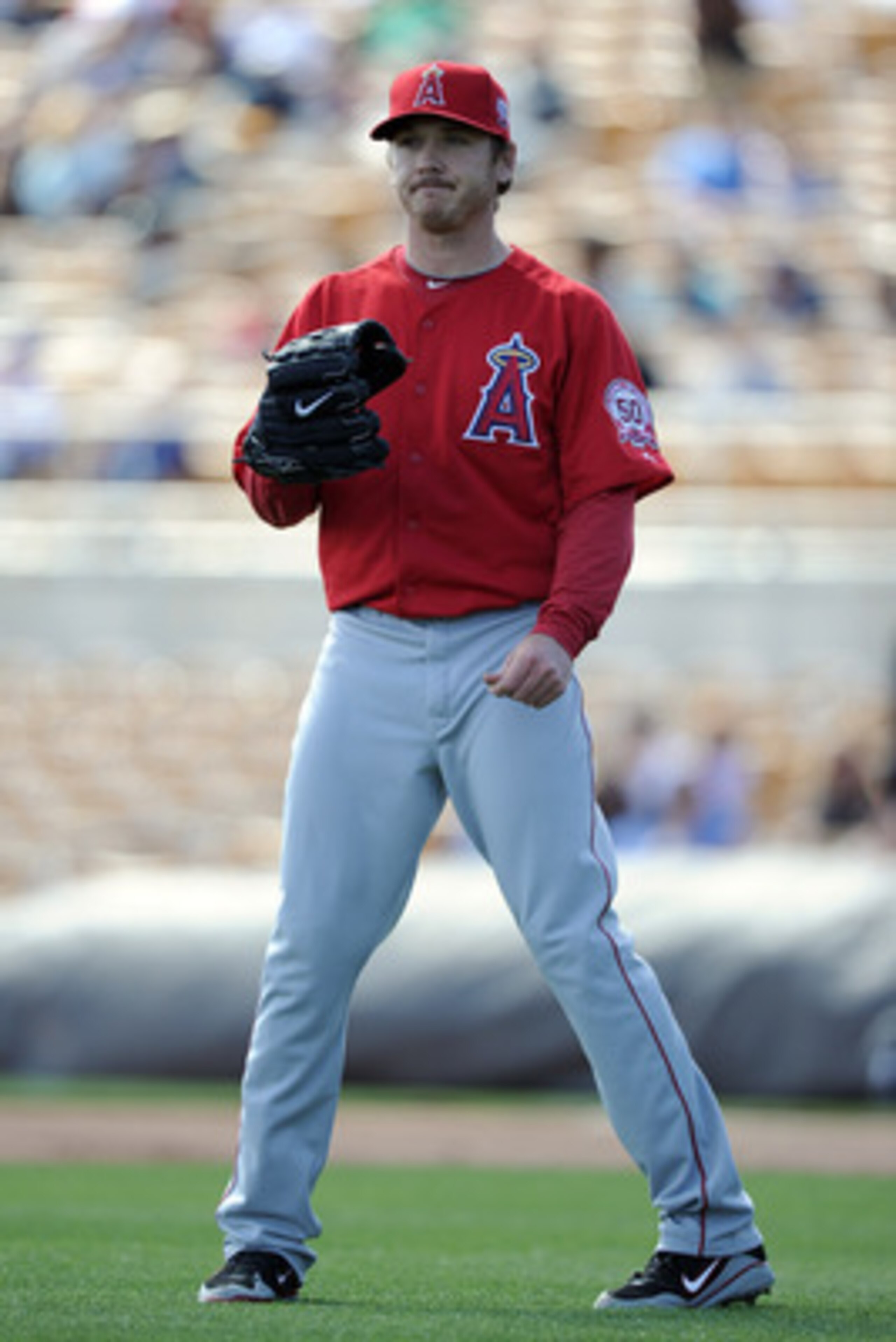PHOENIX, AZ - FEBRUARY 27:  Scott Kazmir #22 of the Los Angeles Angels of Anaheim reacts to a hit by the Los Angeles Dodgers during spring training at Camelback Ranch on February 27, 2011 in Phoenix, Arizona.  (Photo by Harry How/Getty Images)