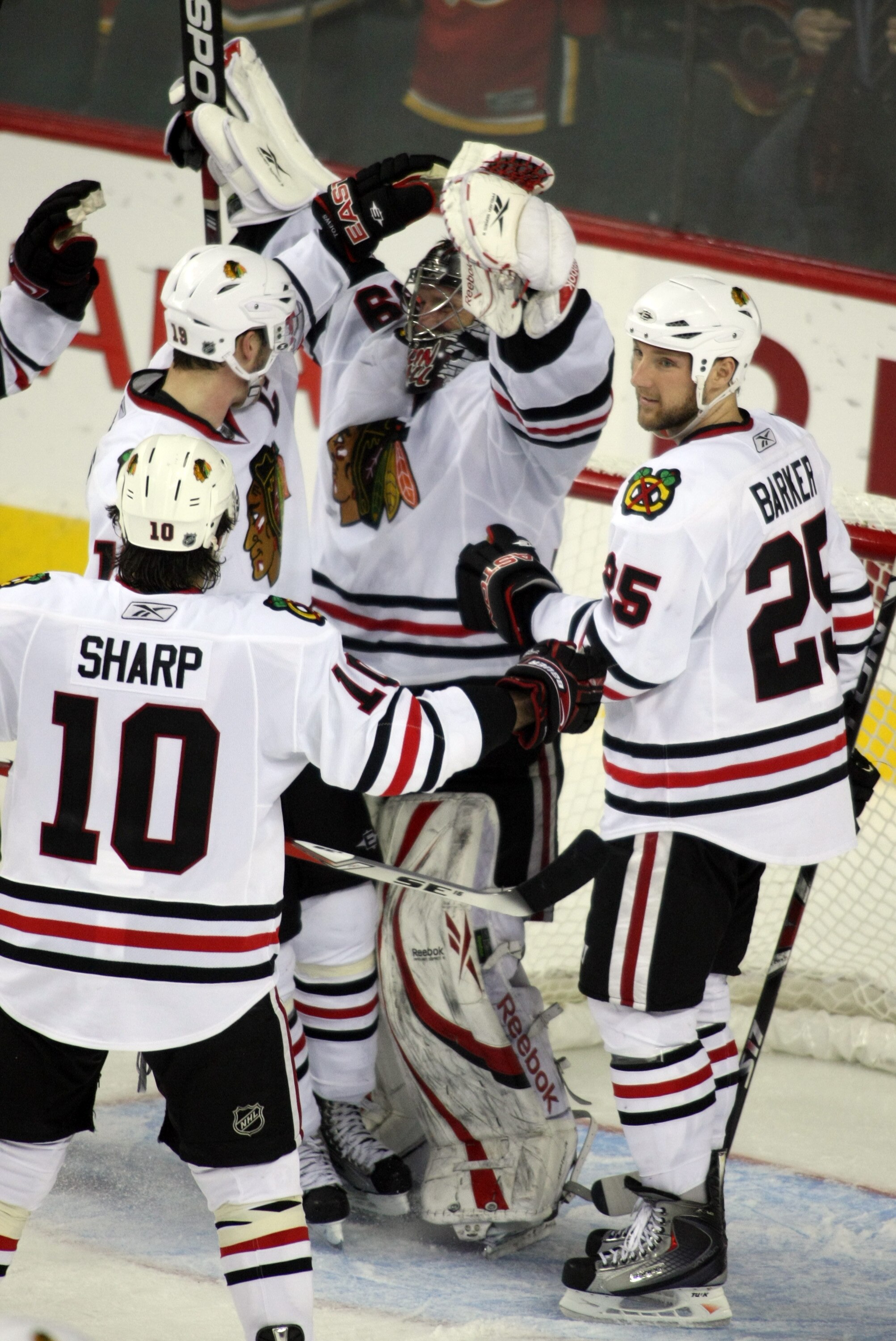 CALGARY, AB - APRIL 27: Goaltender Nikolai Khabibulin (C), Cameron Barker #5, Partrick Sharp #10 and other members of the Chicago Blackhawks celebrate their series win over the Calgary Flames after Game Six of the Western Conference Quarterfinals of the 2