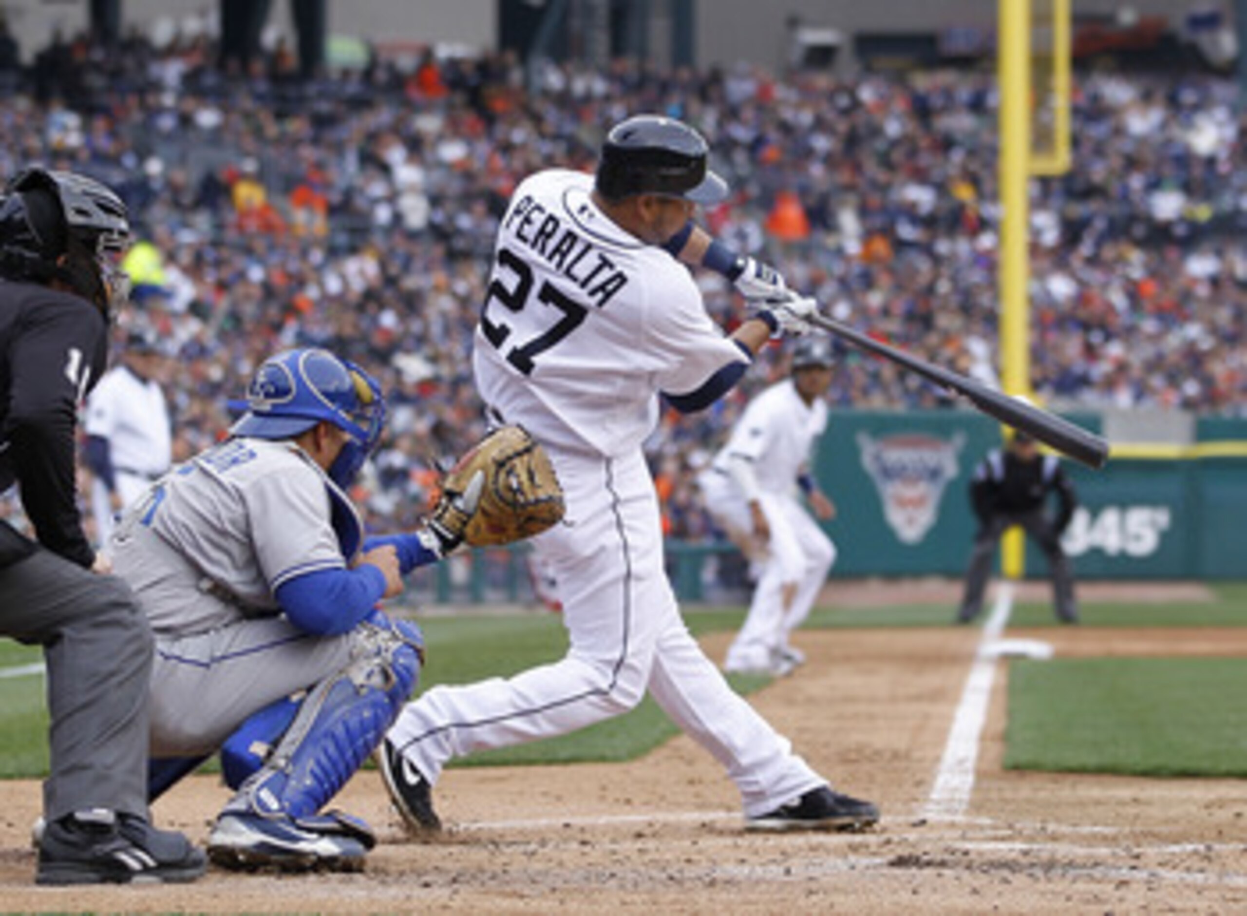 DETROIT, MI - APRIL 08:  Jhonny Peralta #27 of the Detroit Tigers hits a first inning RBI in front of Matt Treanor #15 of the Kansas City Royals during Opening Day at Comerica Park on April 8, 2011 in Detroit, Michigan.  (Photo by Gregory Shamus/Getty Ima